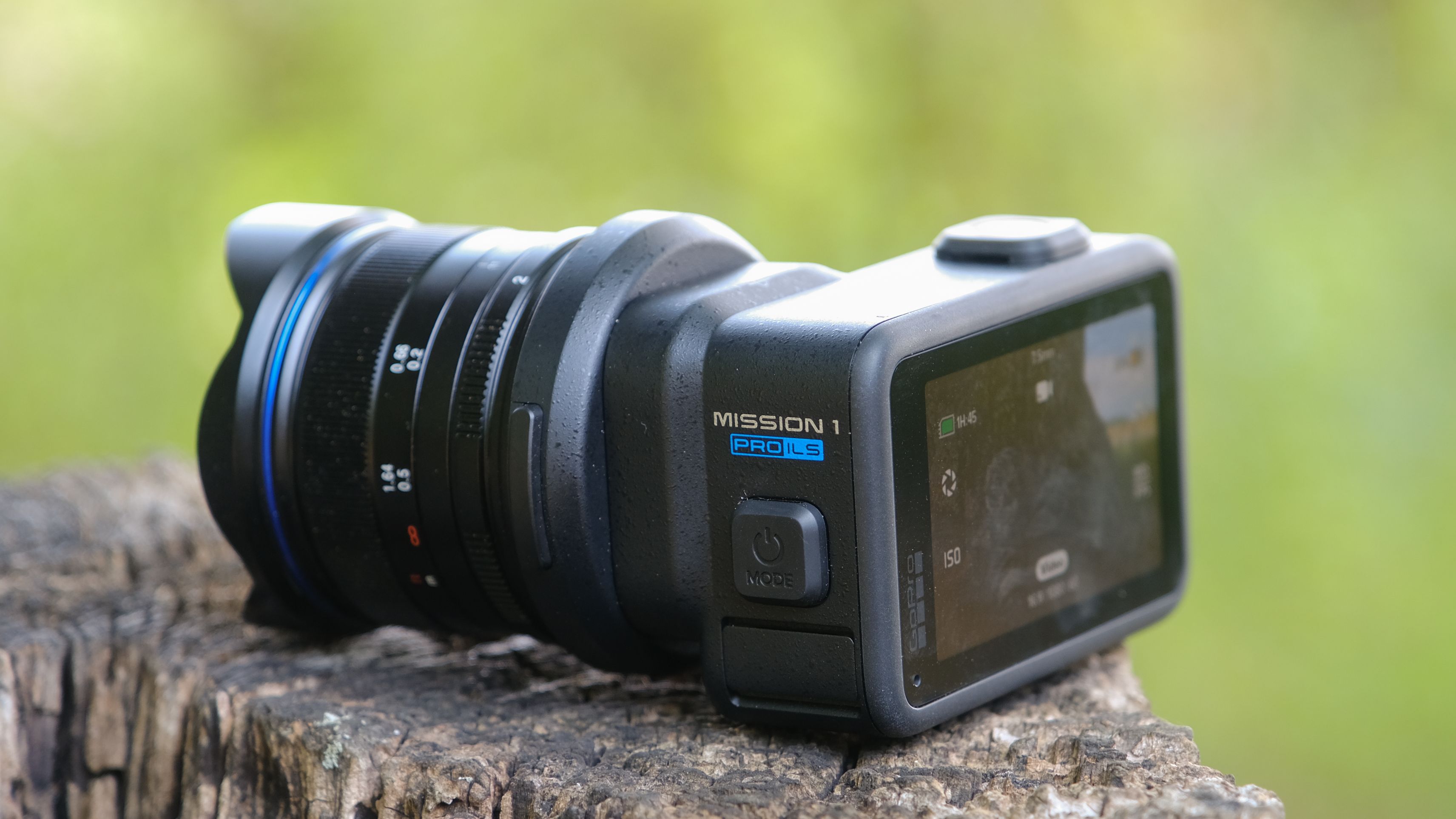 The GoPro Mission 1 ILS mirrorless camera photographed outdoors on a tree stump