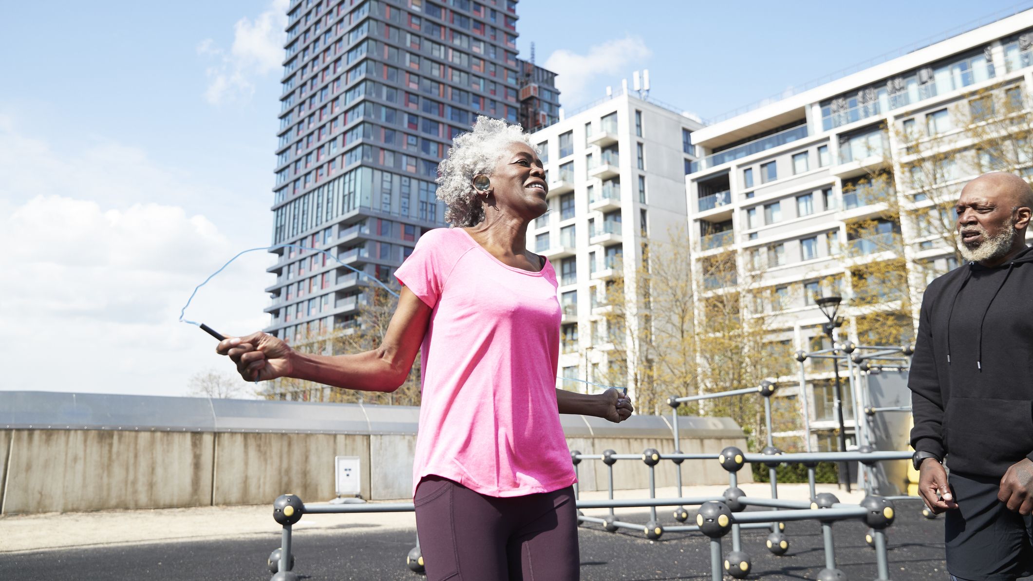 Senior couple exercising with jump rope in urban setting
