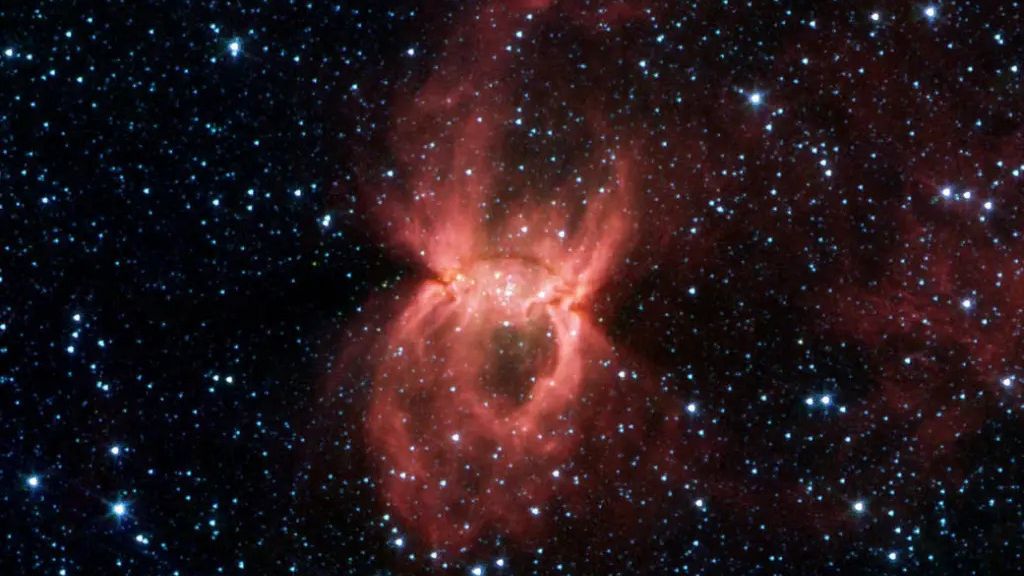 Spitzer Space Telescope image, the two opposing bubbles are being formed in opposite directions by the powerful outflows from massive groups of forming stars. The baby stars can be seen as specks of yellow where the two bubbles overlap.