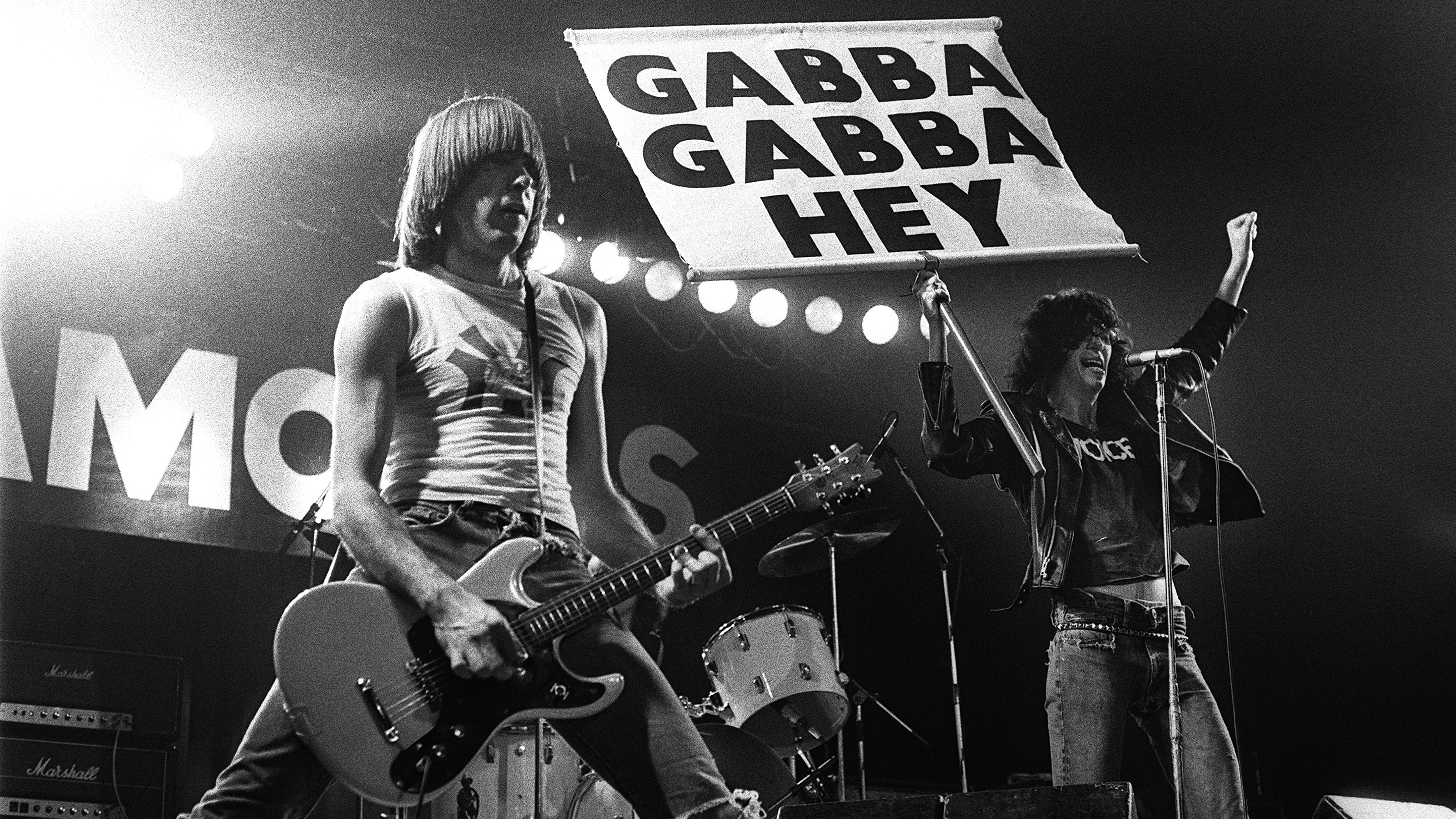 UNITED KINGDOM - DECEMBER 21: MANCHESTER APOLLO Photo of RAMONES and Johnny RAMONE and Joey RAMONE, Johnny (L) and Joey Ramone performing on stage, sign (Photo by Howard Barlow/Redferns)