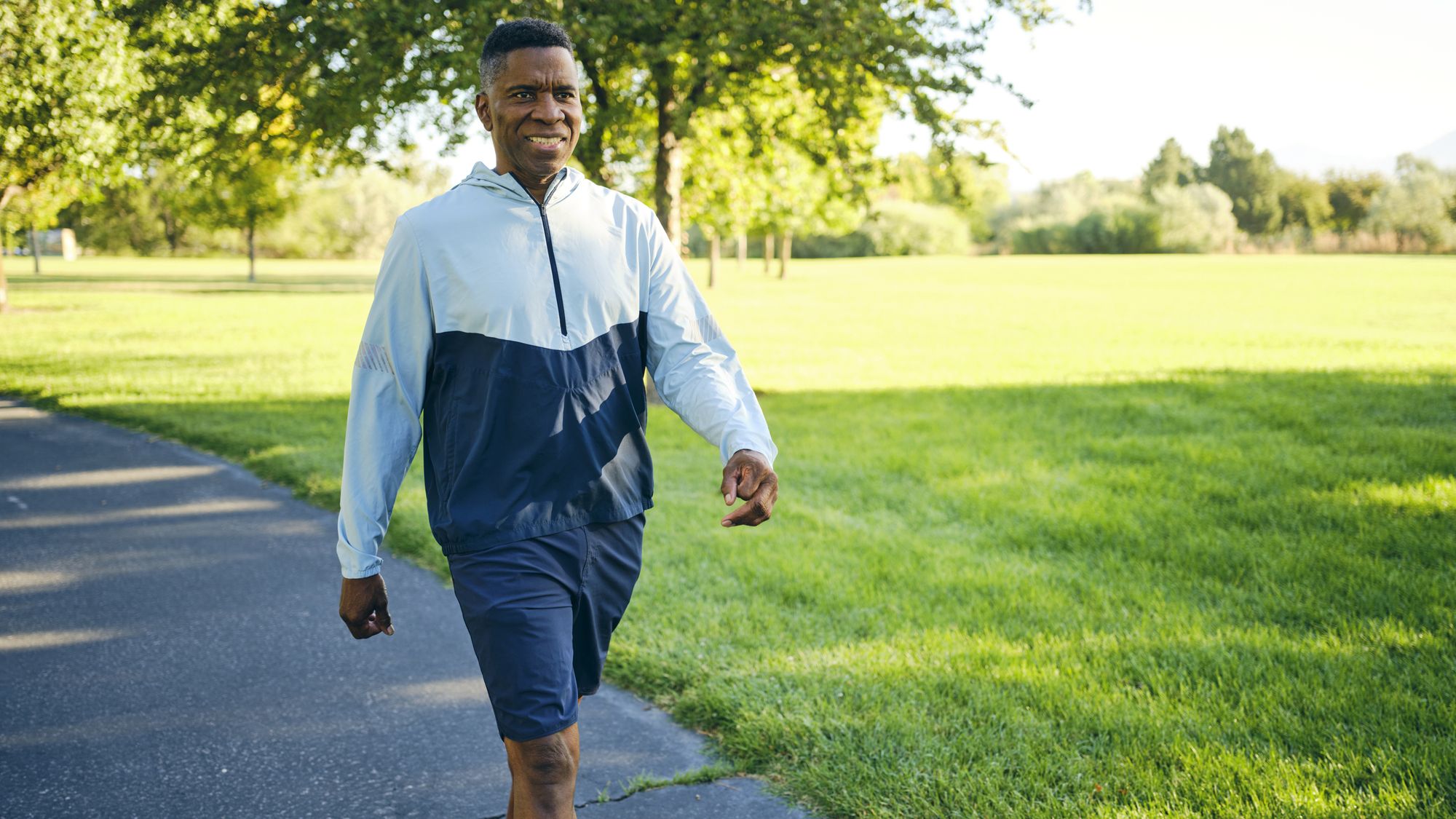 Man in activewear walking in sunny park