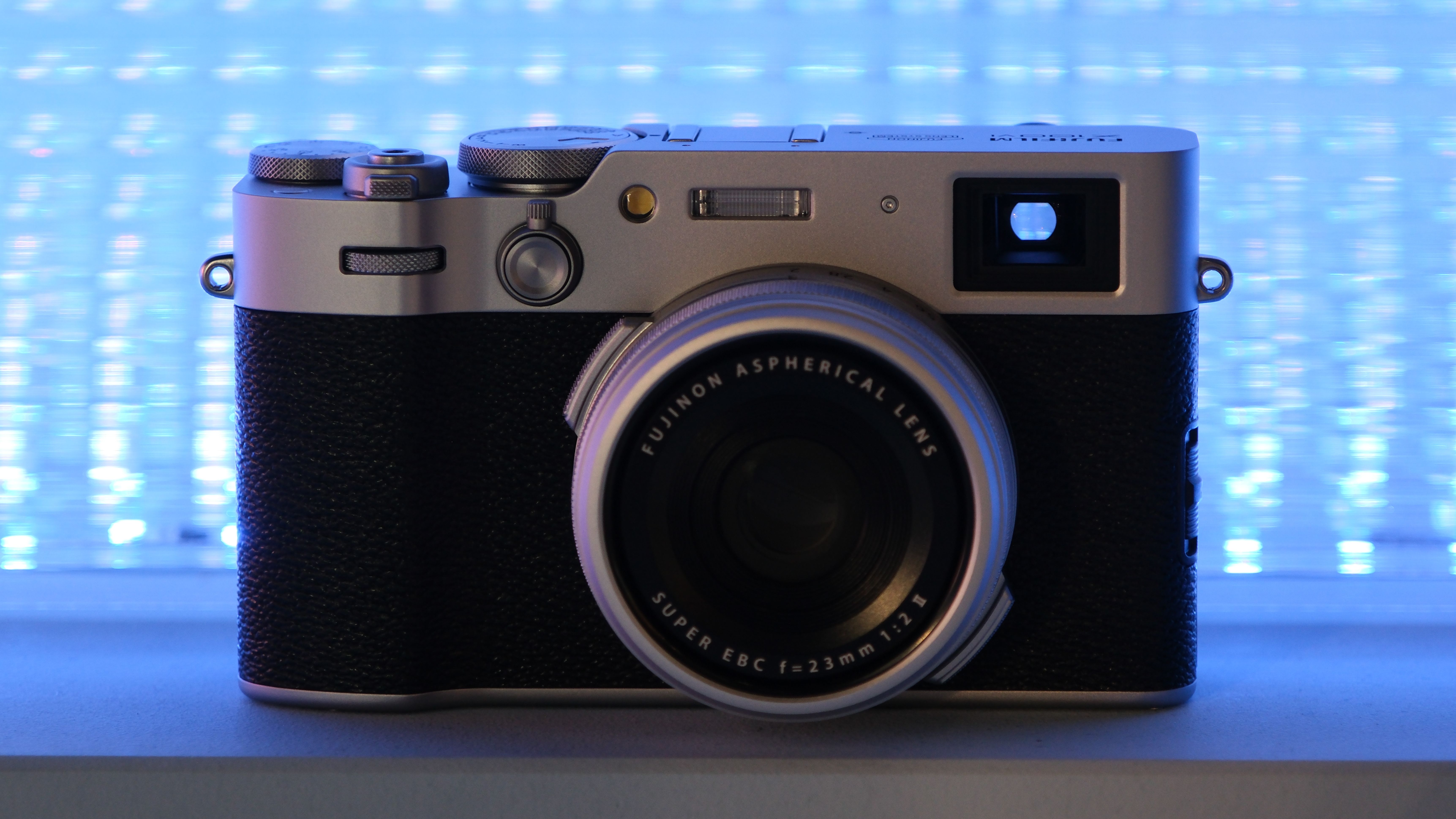Fujifilm X100VI camera in front of a blue neon light