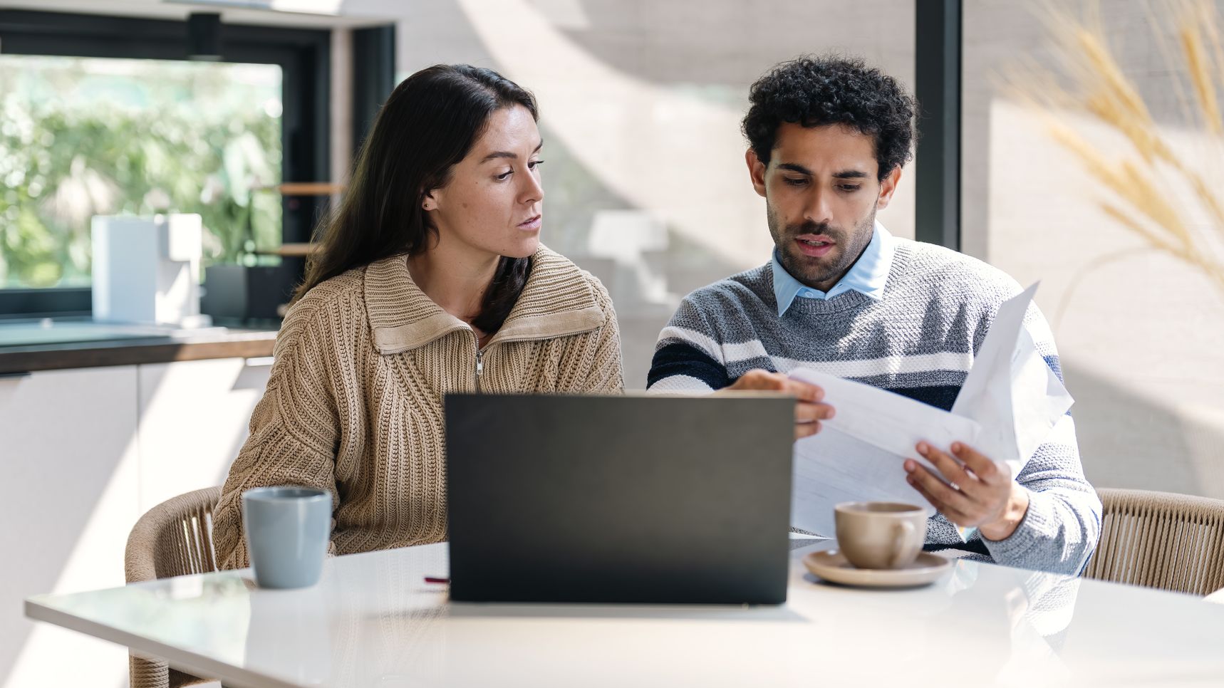 a couple going over their finances at a kitchen table