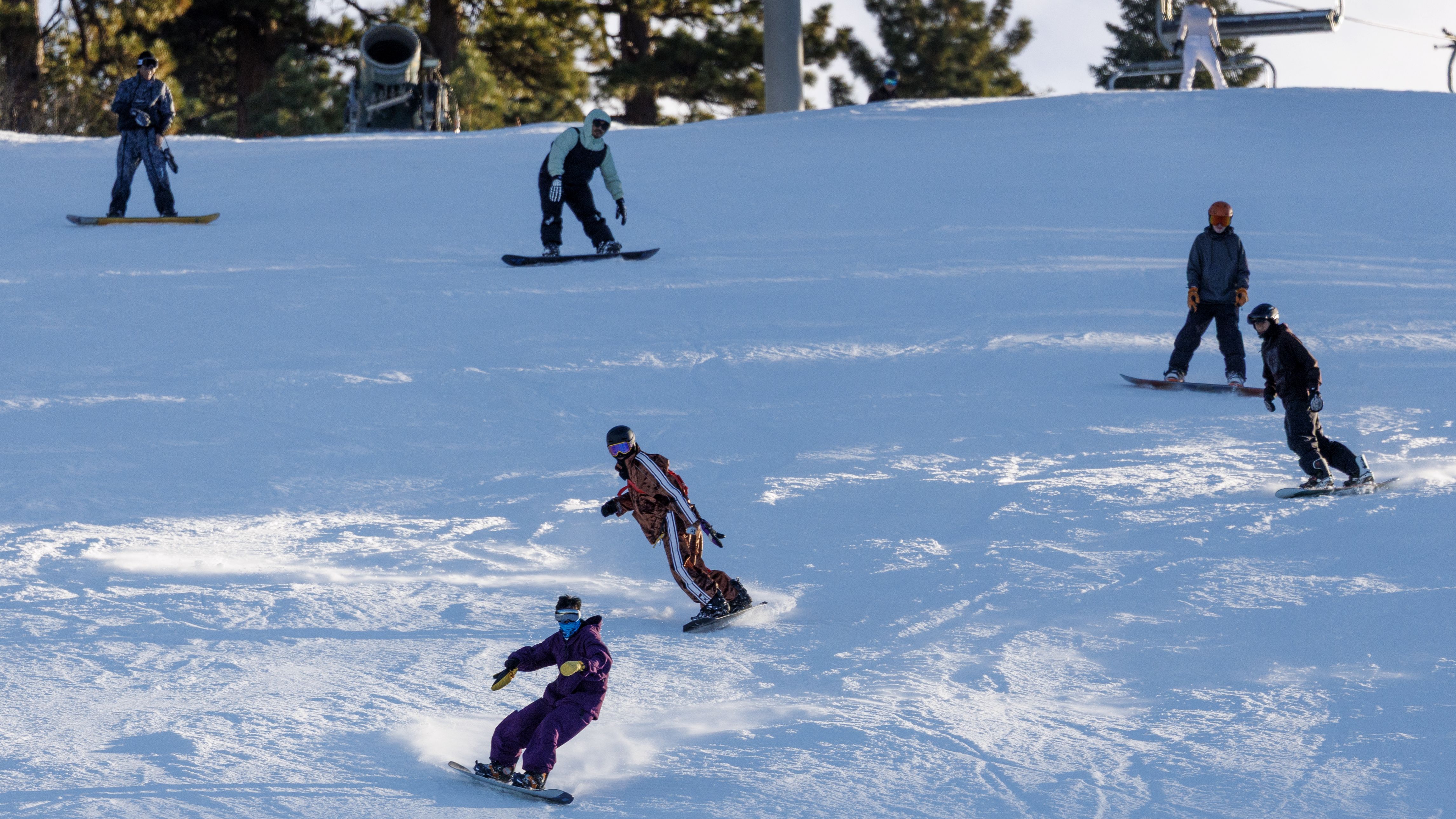 Snowboarders traverse down the slope on opening day at Big Bear Mountain on December 4, 2025 in Big Bear Lake, California.(Gina Ferazzi / Los Angeles Times via Getty Images)