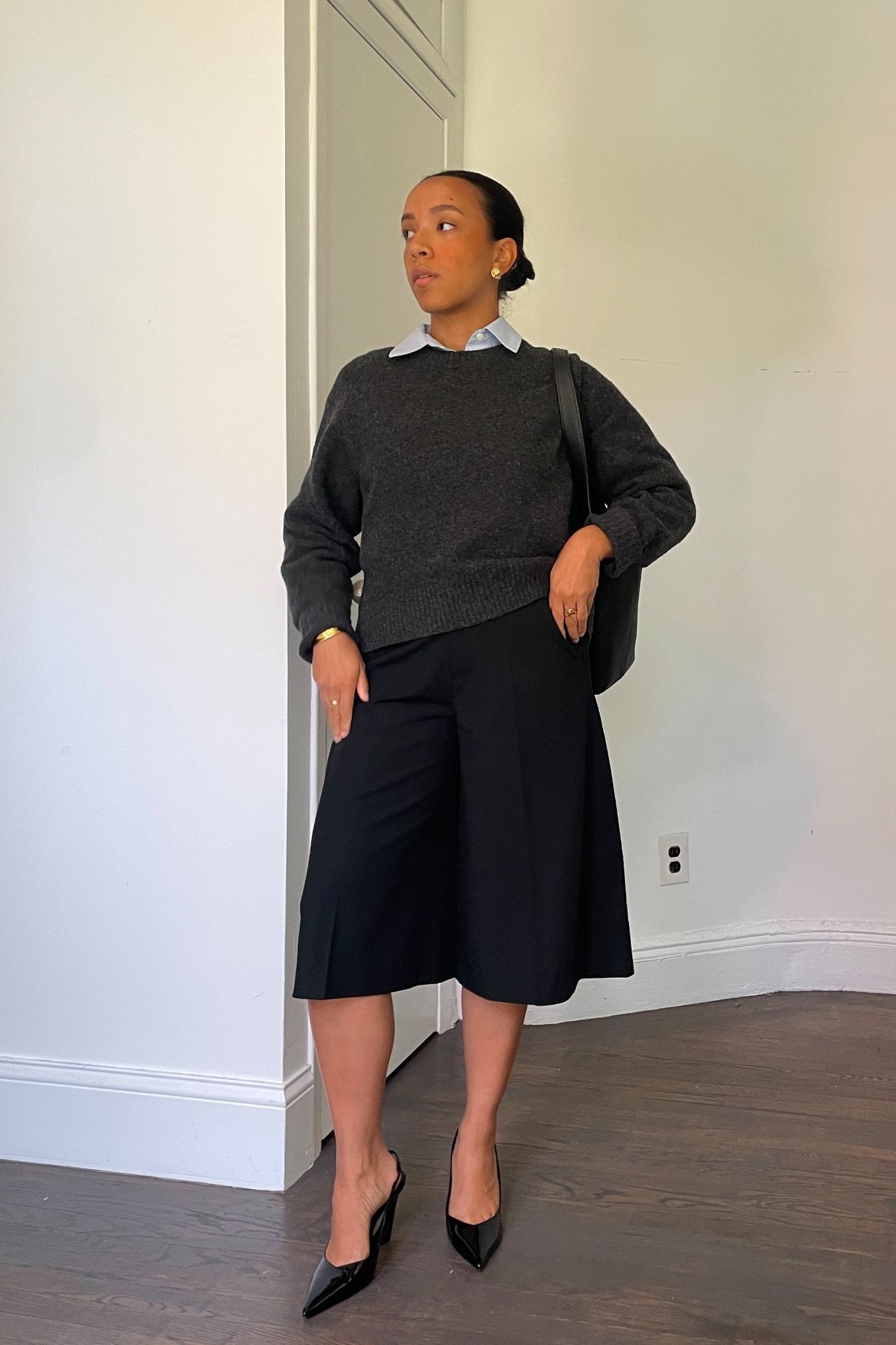 Lauren Tappan wearing a sweater, tailored Bermuda shorts, and heels