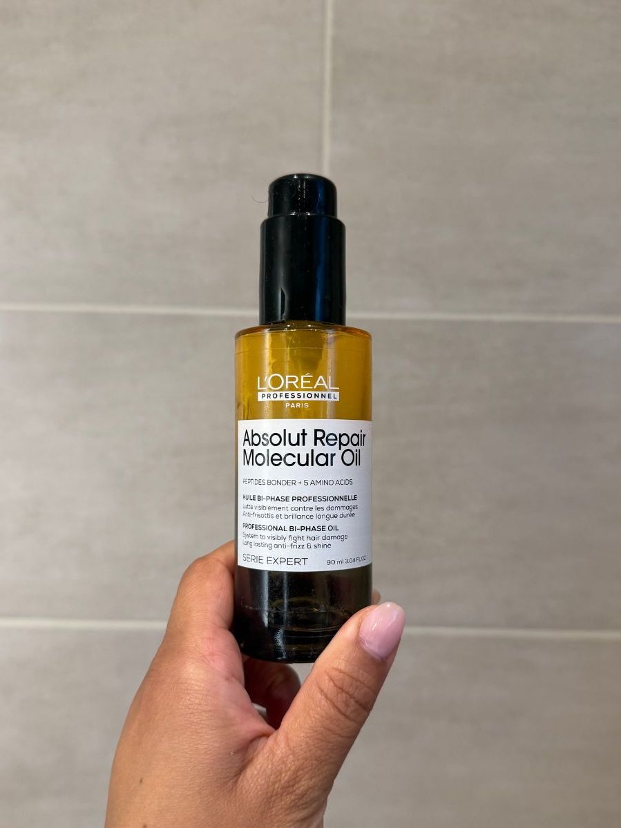 Aleesha holding empty Loreal Absolut Repair Molecular Oil