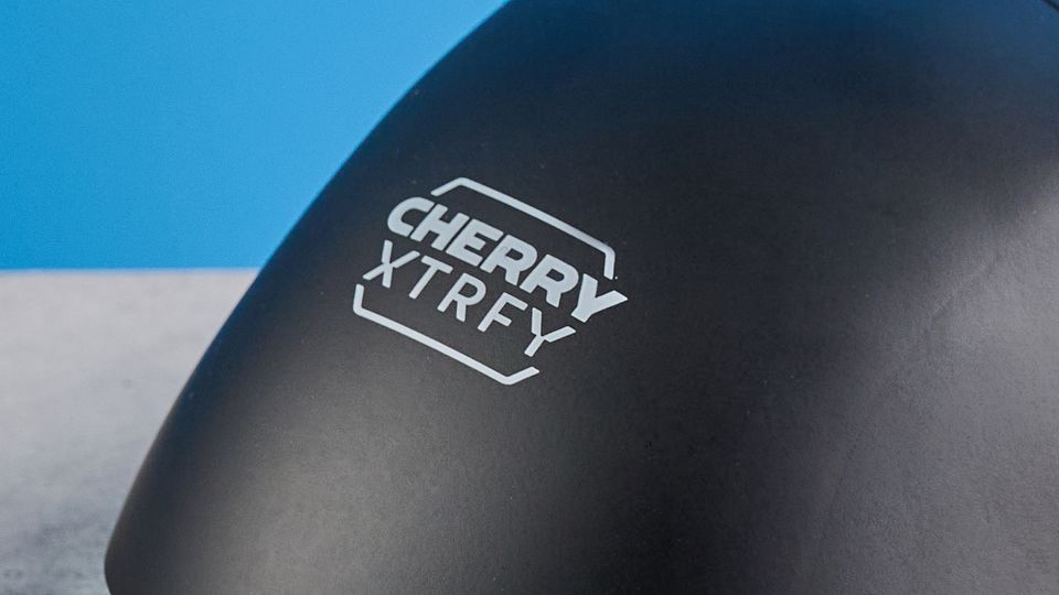A black and teal Cherry XTRFY M64 Wireless gaming mouse