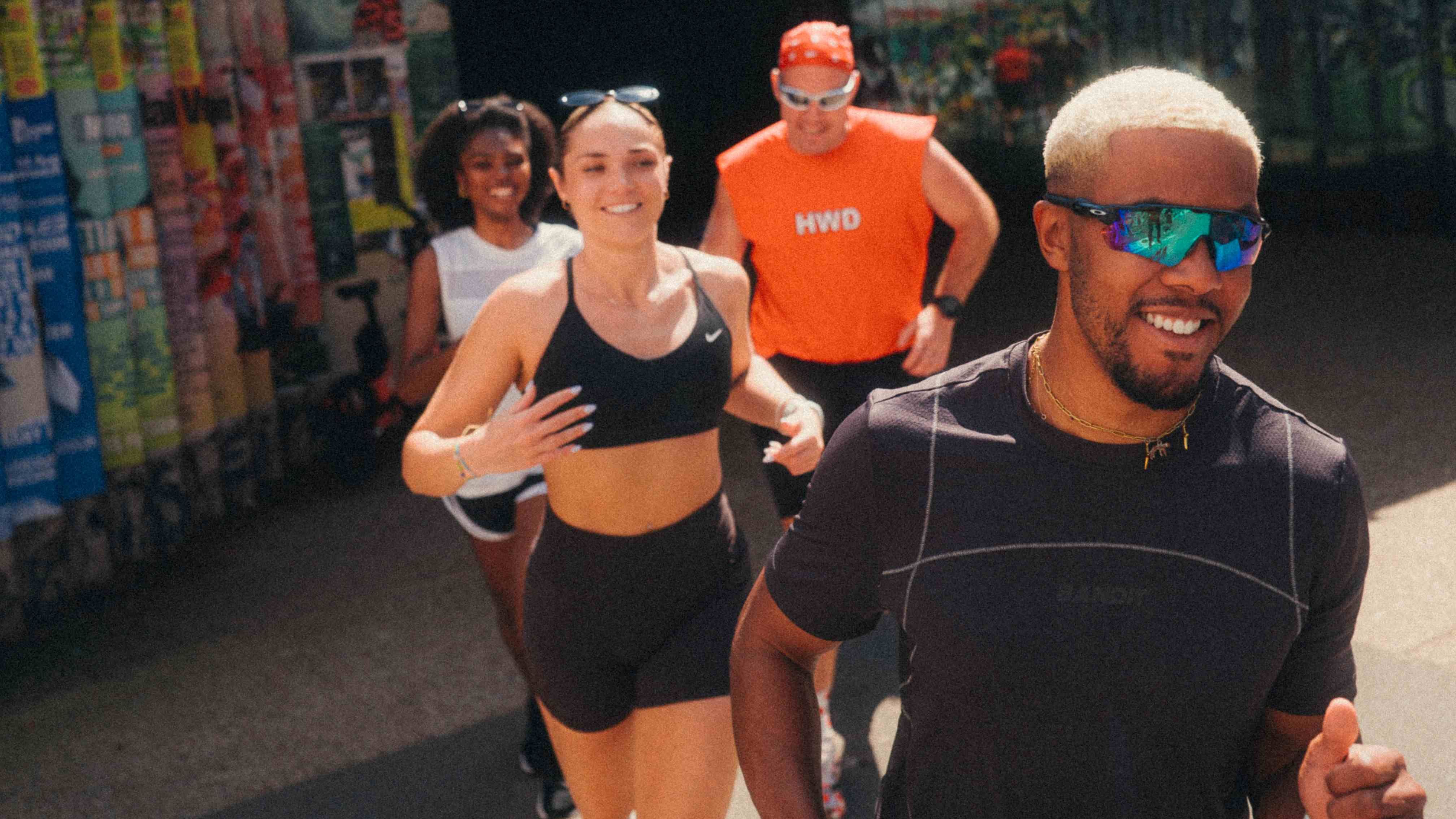 an image of four friends running across London, coming out of Hackney Wick tube station