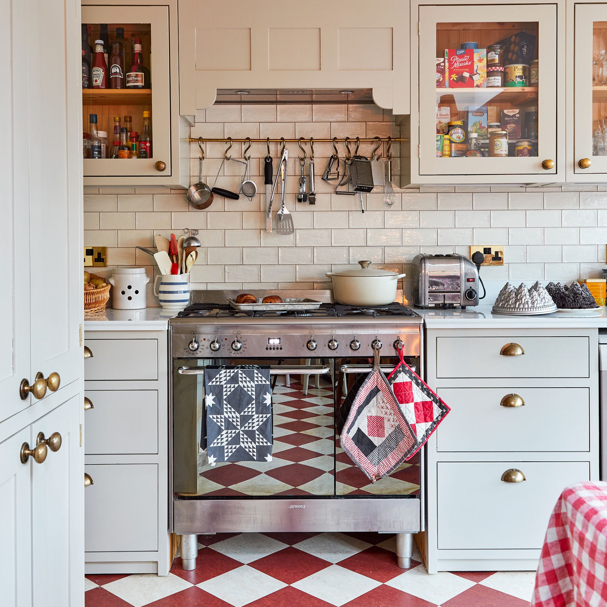 view towards range cooker in a neutral kitchen with red and white chequered floor tiles
