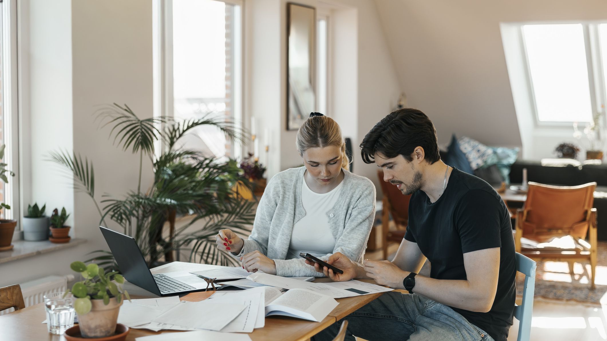 Young couple calculating savings while doing bookkeeping at home