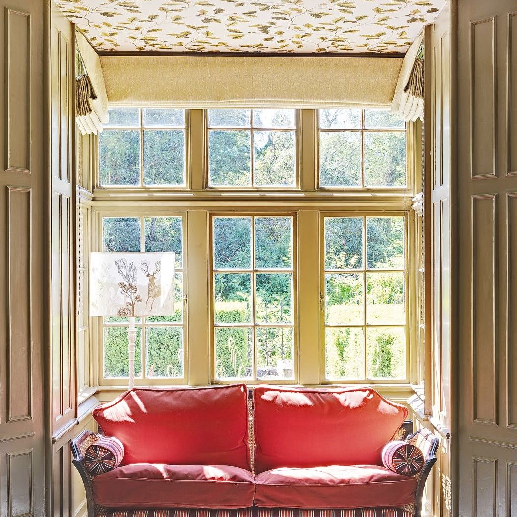 Alcove with bay window in period living room with wallpapered ceiling