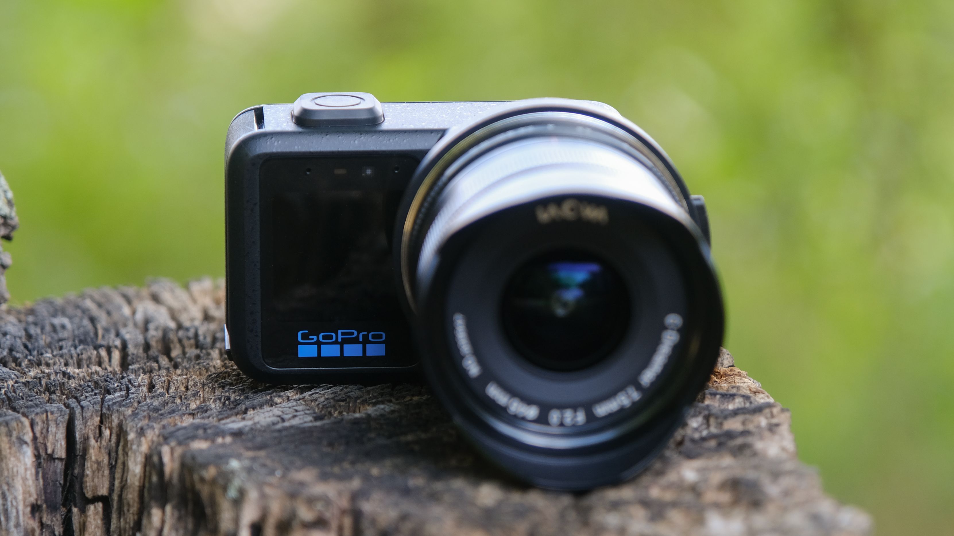 The GoPro Mission 1 ILS mirrorless camera photographed outdoors on a tree stump