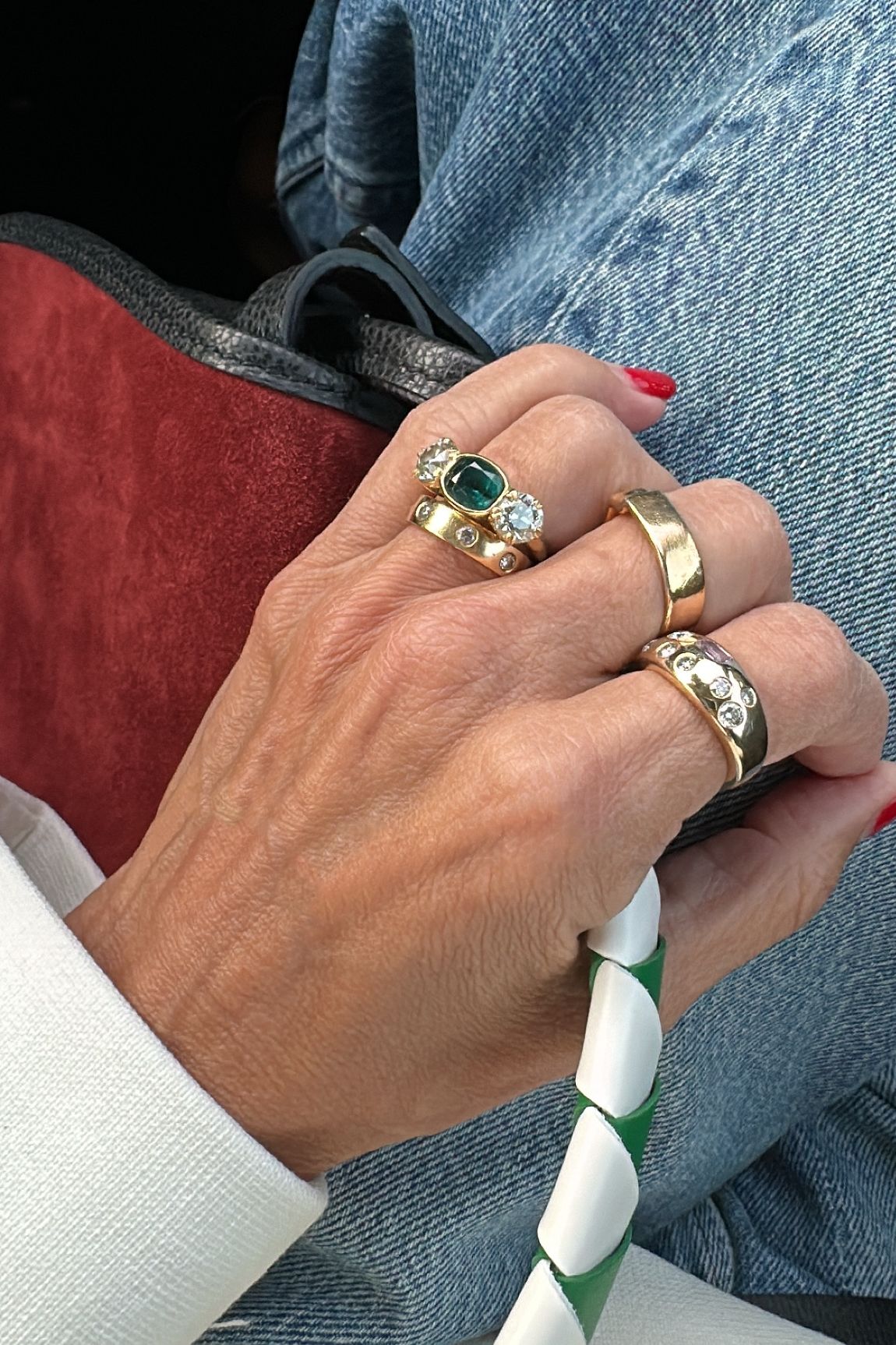 a close-up image of Larissa Mills wearing a stack of silver and gold rings
