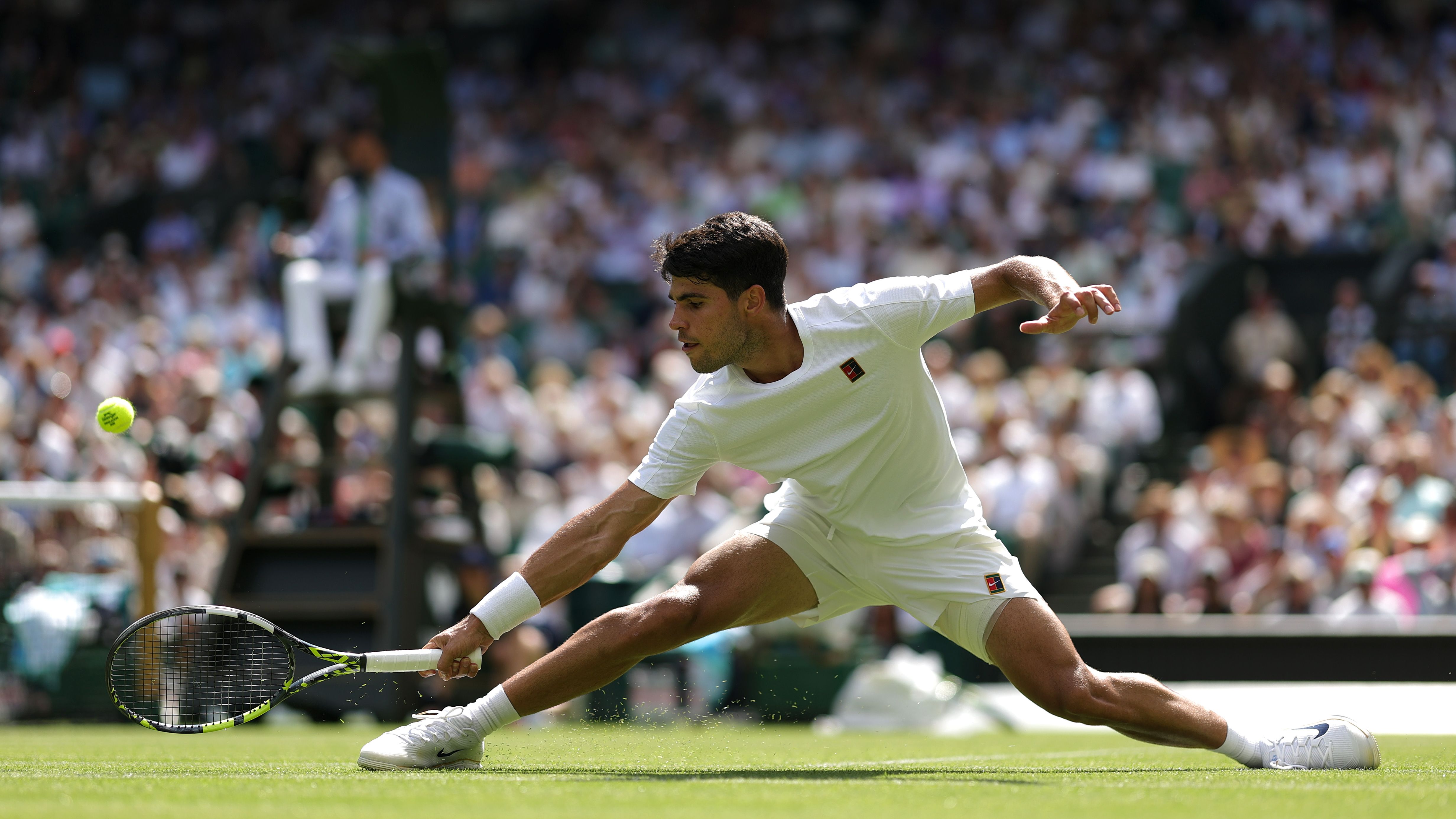 Carlos Alcaraz of Spain plays a backhand to Fabio Fognini of Italy during the Gentlemen's Singles first round match on day one of The Championships Wimbledon