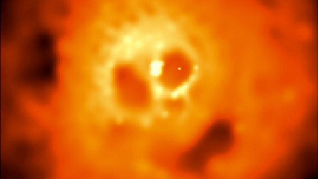 a glowing orange cloud of material looks like a skull.