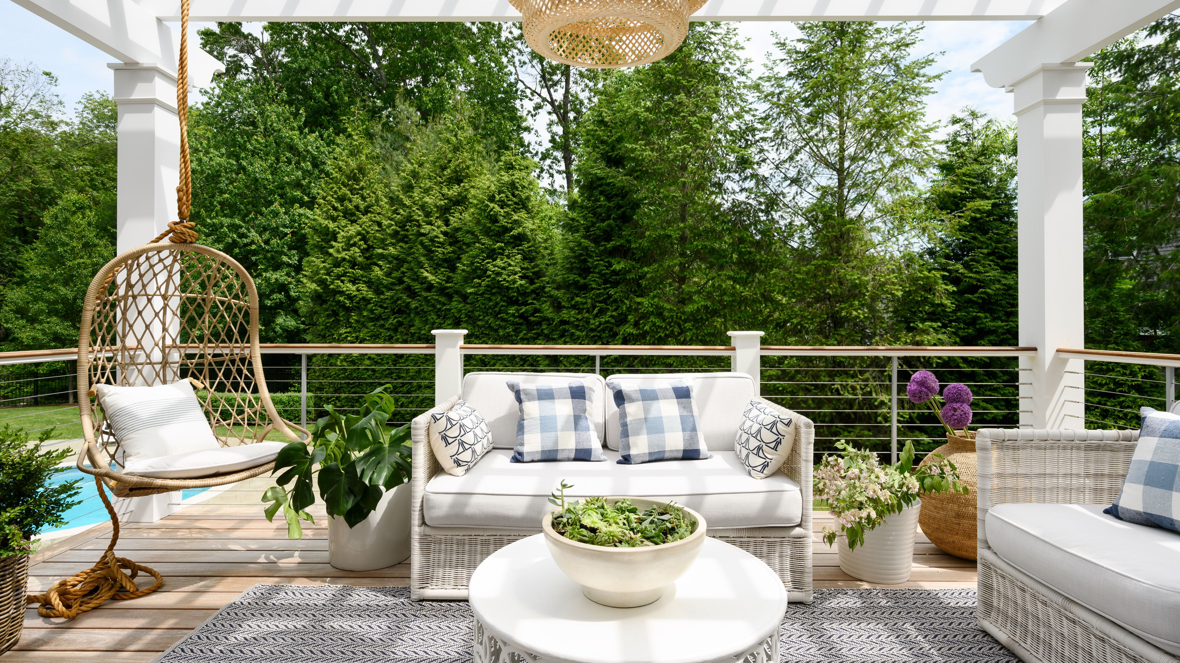 white patio furniture on a deck with pergola