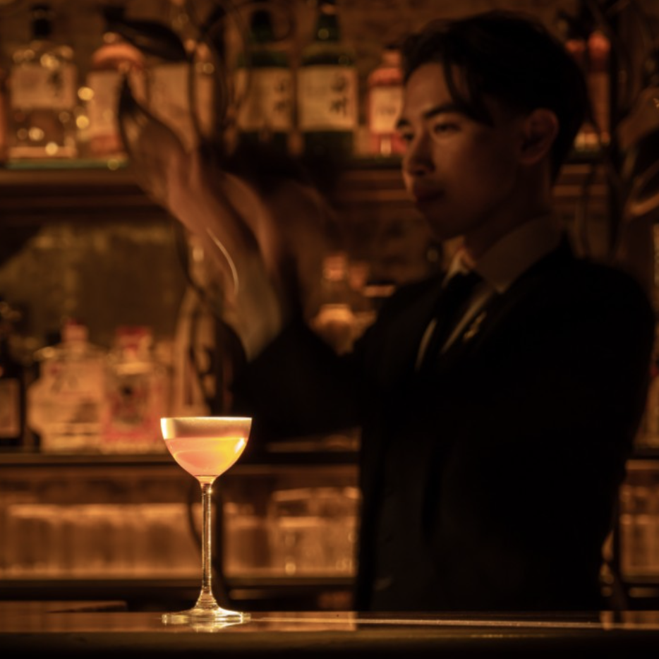 an image of a bartender mixing a cocktail behind the bar at Kiyori, with a martini style cocktail in front of him sitting on the bar
