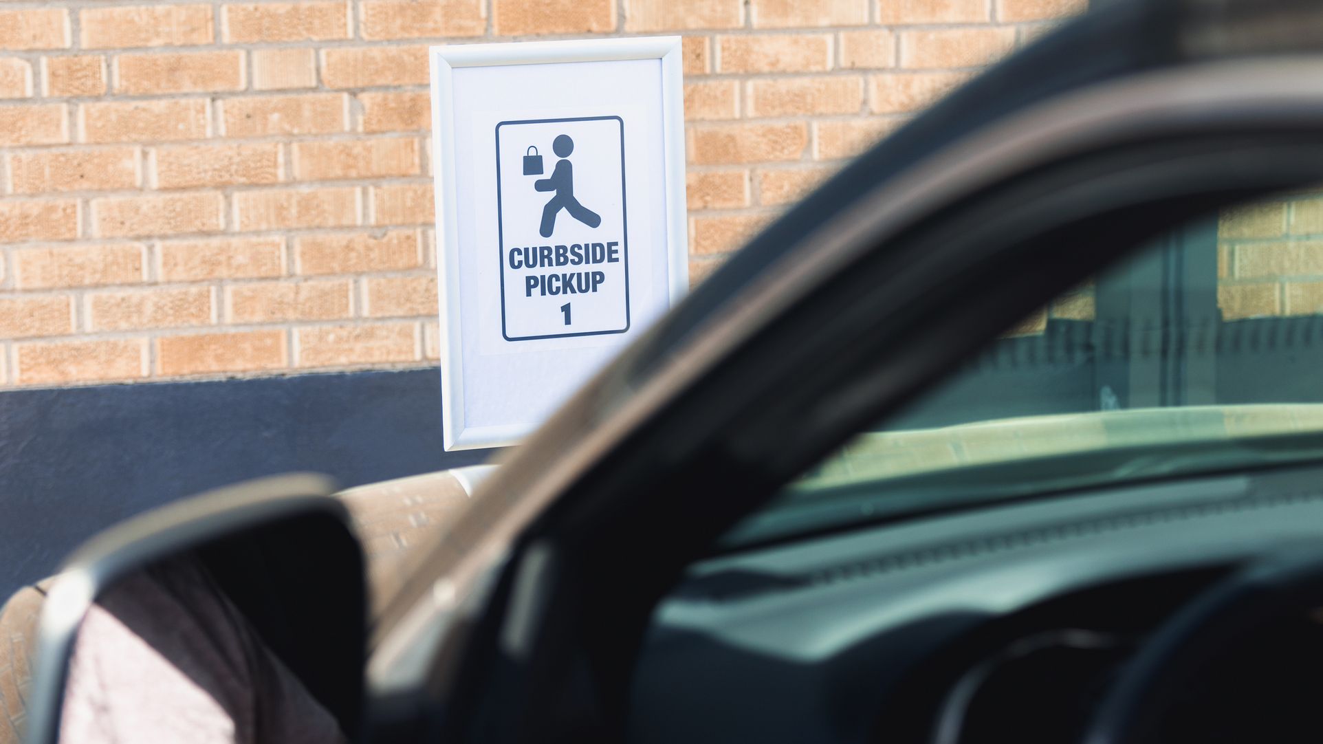 A car parked in a curbside pick up spot.