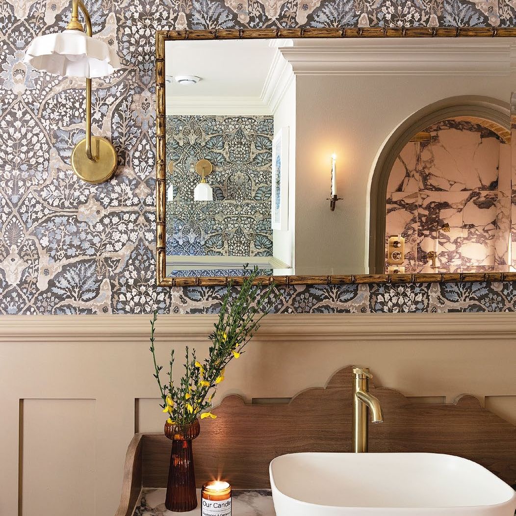 Bathroom with basin on wood and marble vanity unit beneath walls with half panels and half wallpaper
