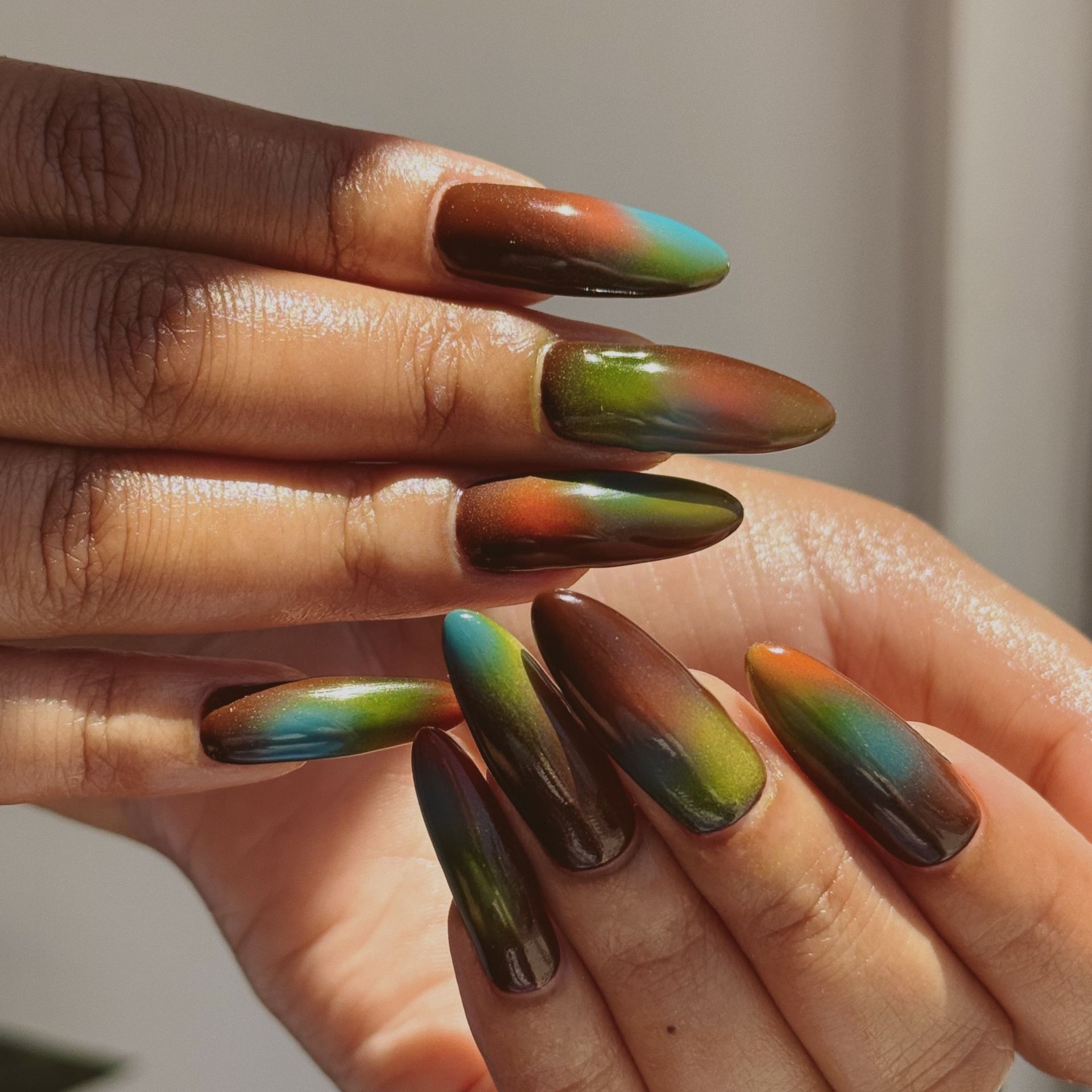 green aura manicure with blue and brown and orange