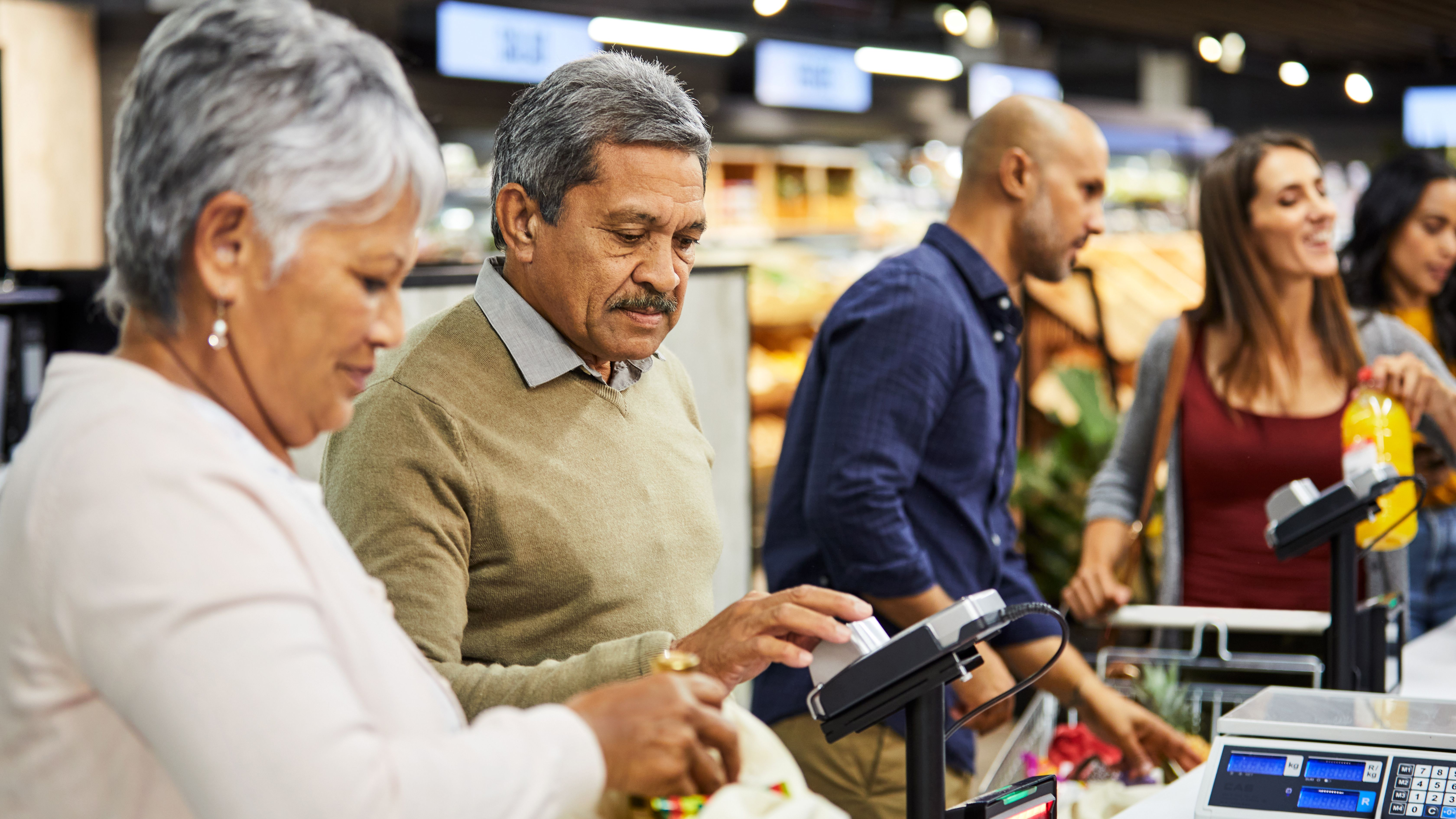 Shot of an elderly couple paying for their groceries in a supermarket