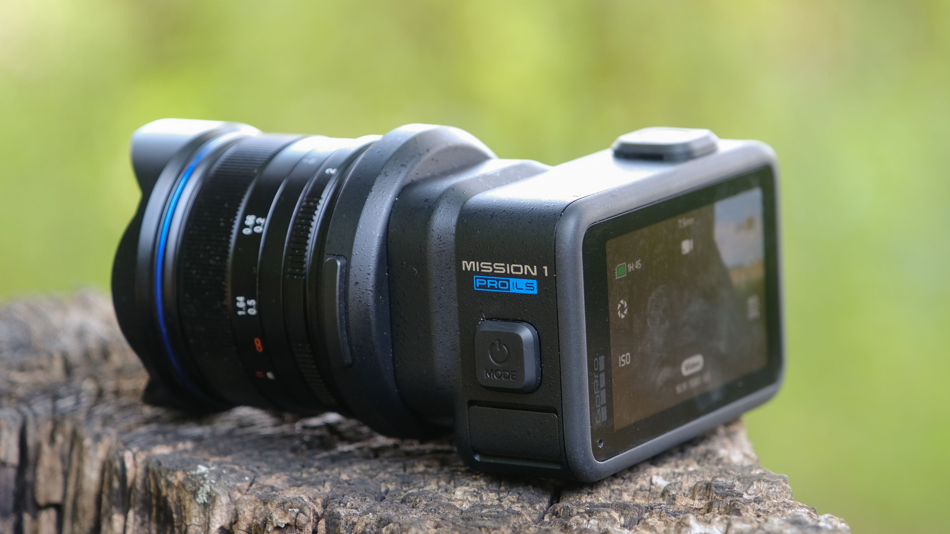 The GoPro Mission 1 ILS mirrorless camera photographed outdoors on a tree stump