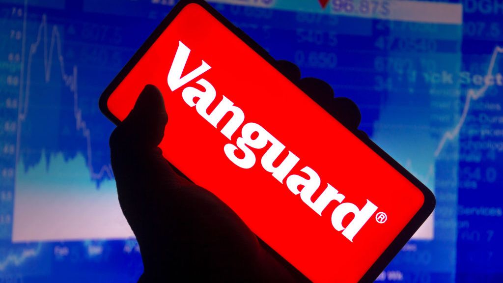 Vanguard logo on smartphone with stock chart in background