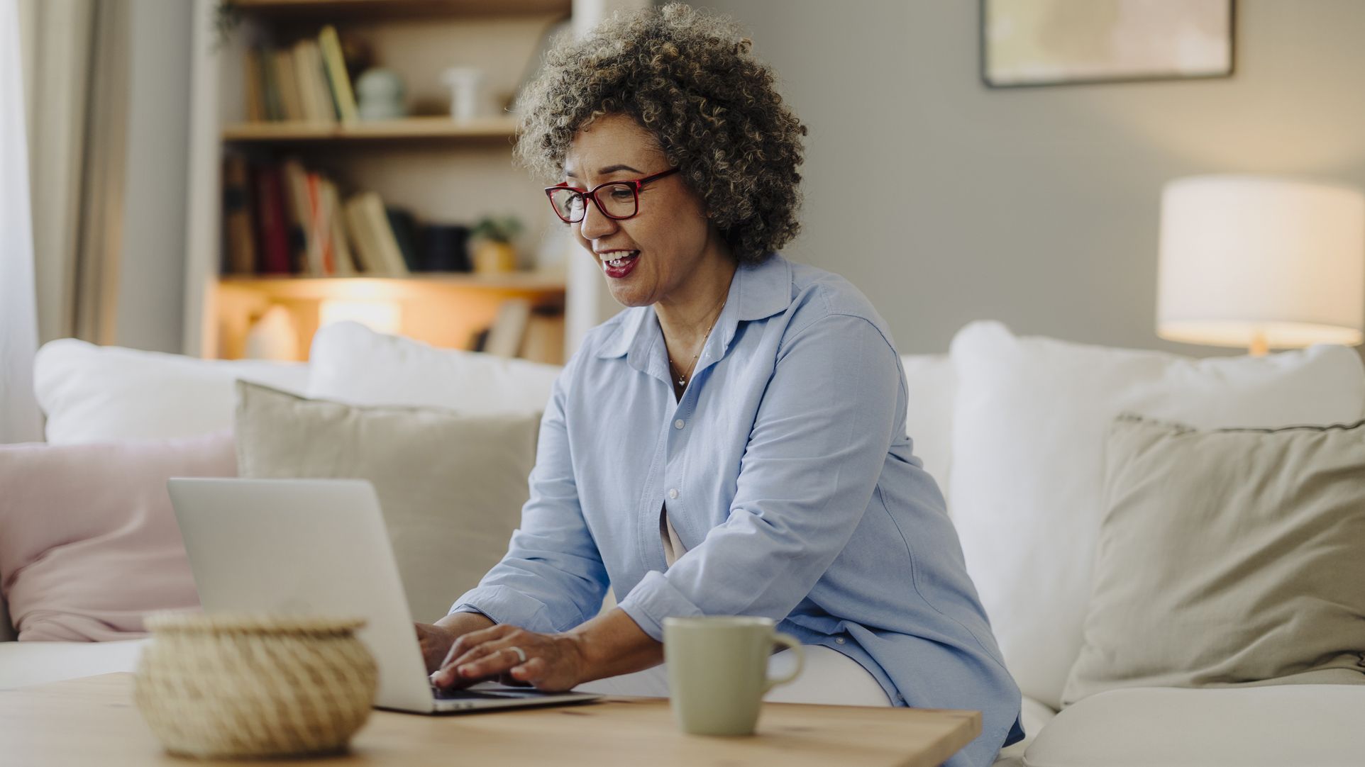 A woman working on a laptop in her living room
