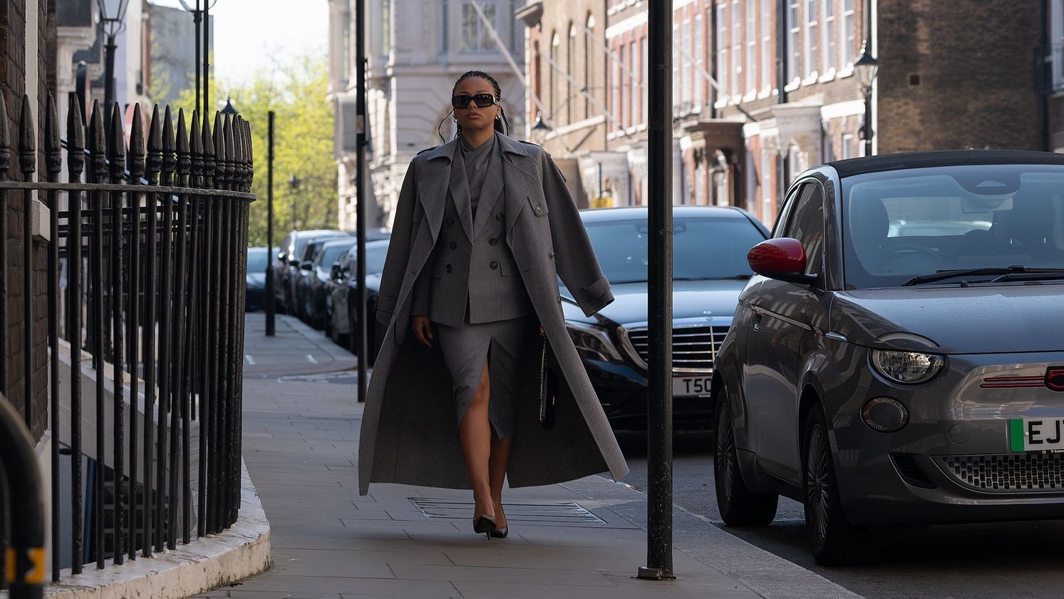 Industry&amp;rsquo;s Harper Stern Myha&amp;rsquo;la wearing a gray coat, gray skirt, black heels, and black Chanel bag.