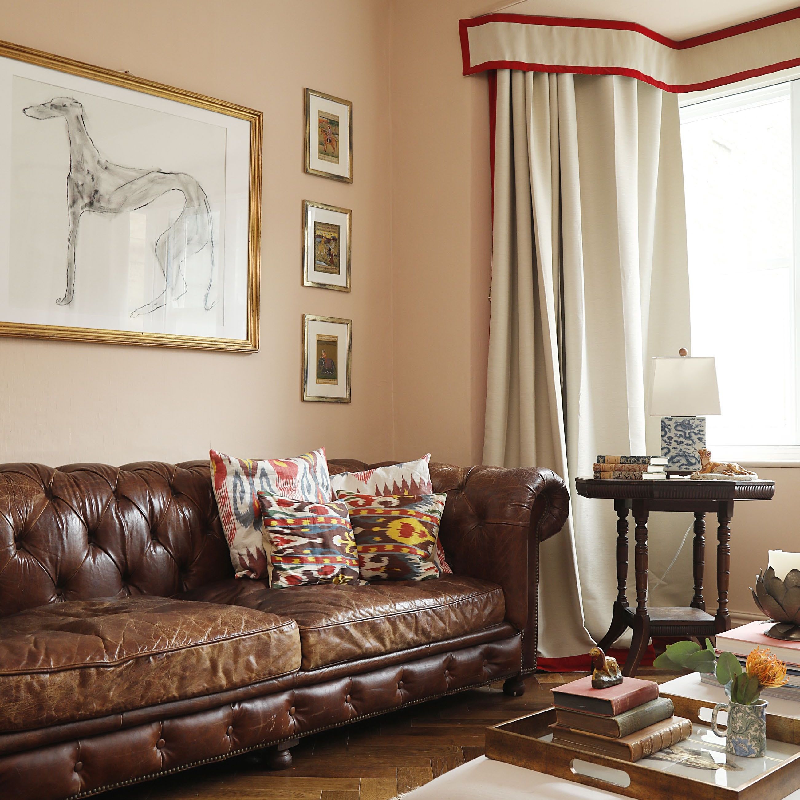 traditional style living rooms in warm neutrals with leather Chesterfield style sofa and curtain pelmet