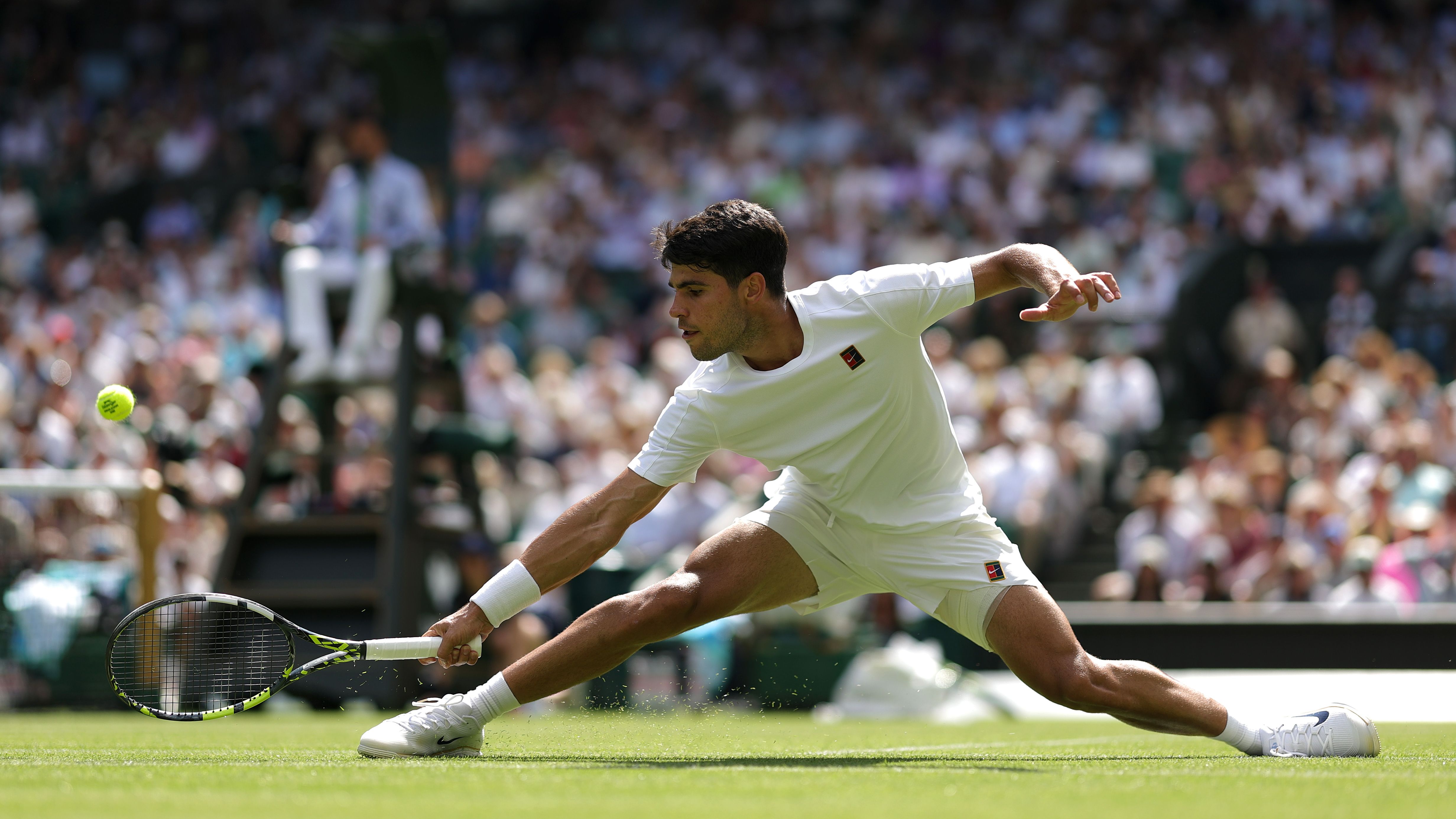 Carlos Alcaraz of Spain plays a backhand to Fabio Fognini of Italy during the Gentlemen's Singles first round match on day one of The Championships Wimbledon