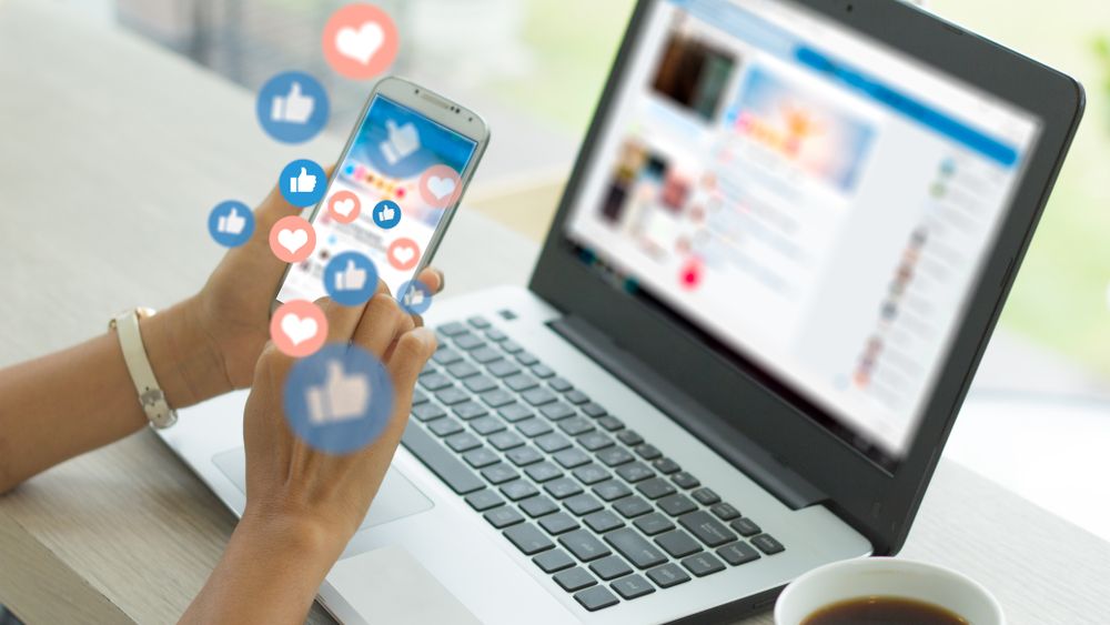 Woman using laptop and phone with social media