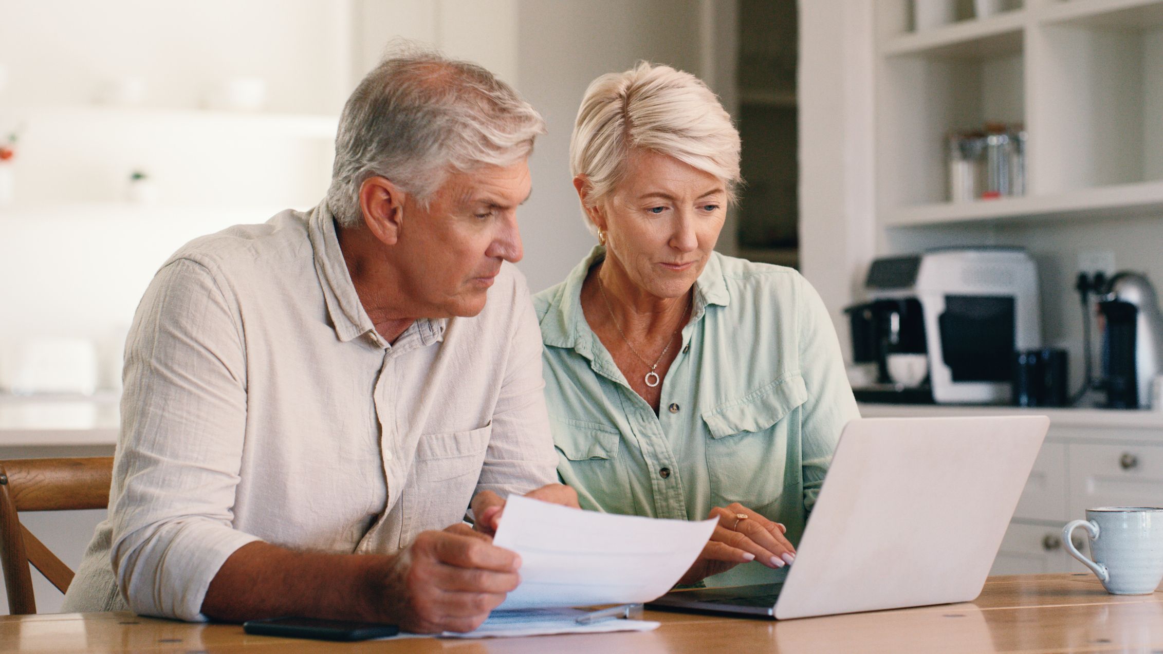 Paperwork, home and senior couple with laptop for finance planning with retirement and pension fund. Computer, documents and elderly man and woman with bank app for mortgage, bills or debt payment.