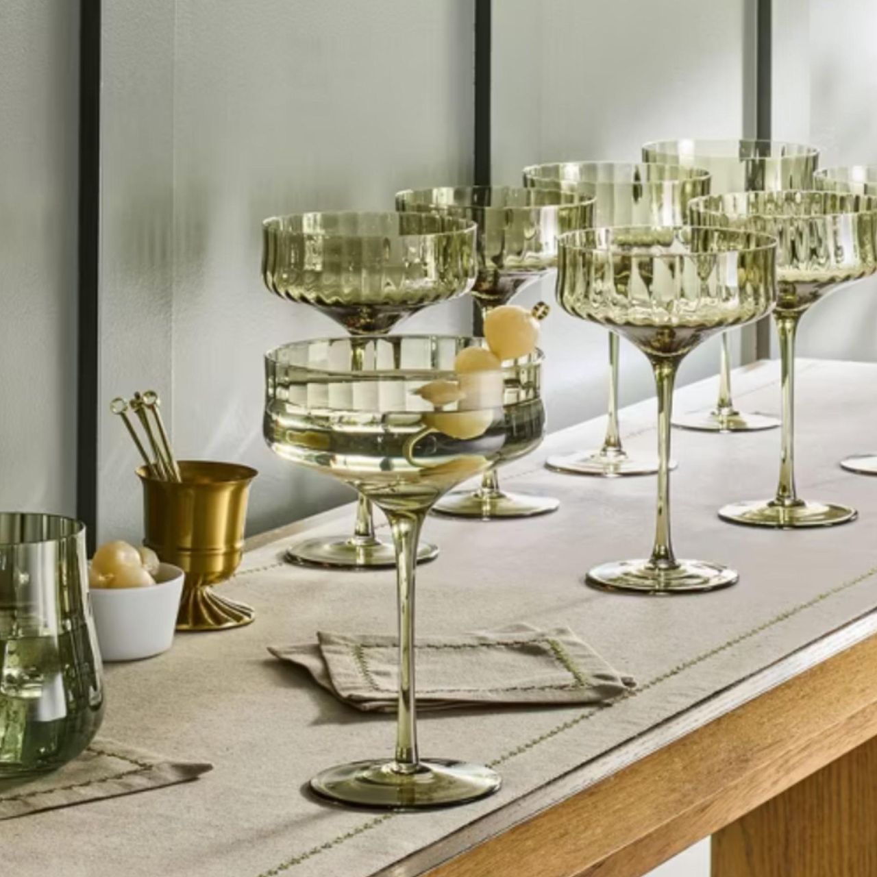 Green coupe glasses on a cocktail table