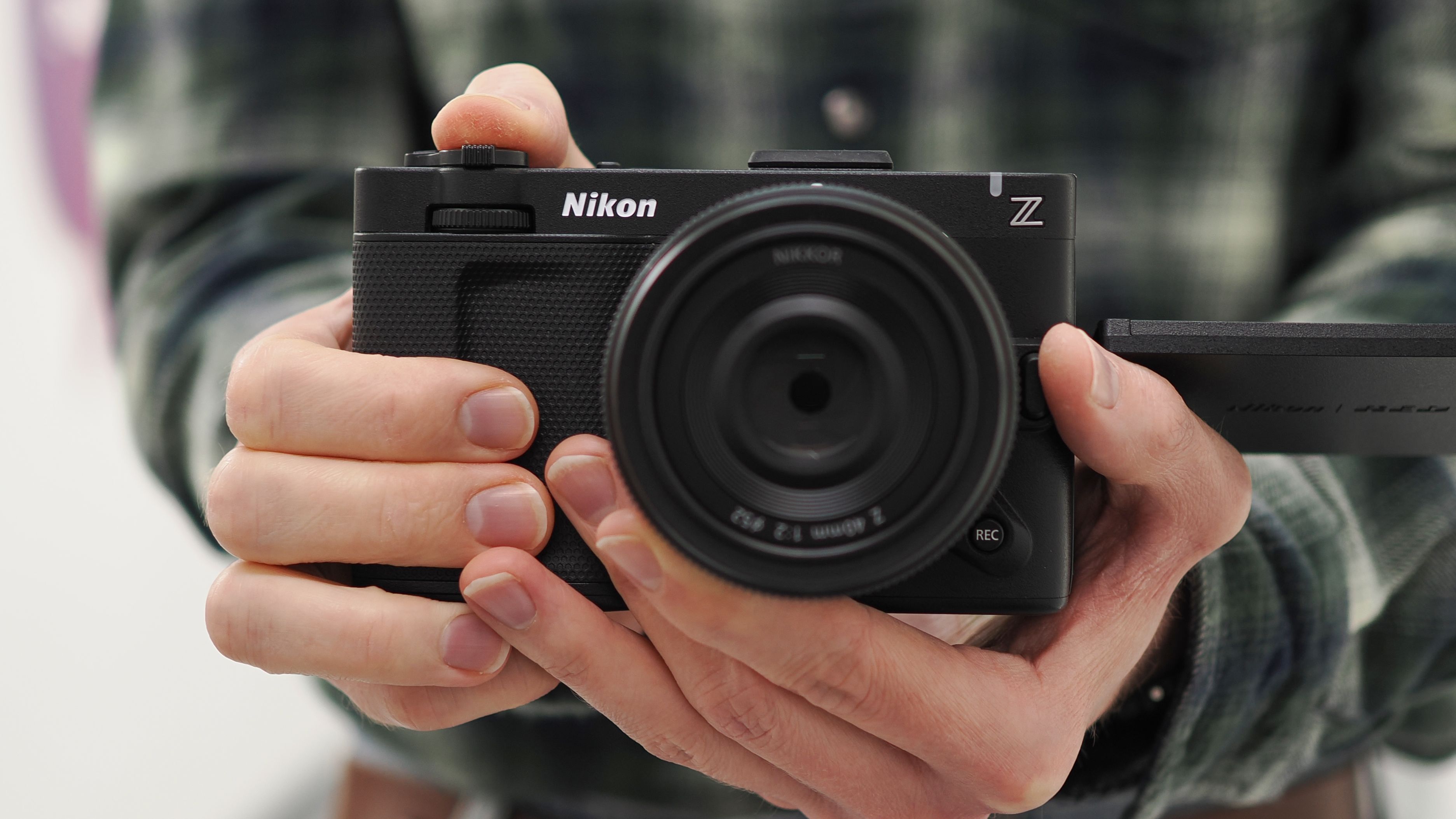 Mike Harris holding a Nikon ZR with 40mm lens in an office building