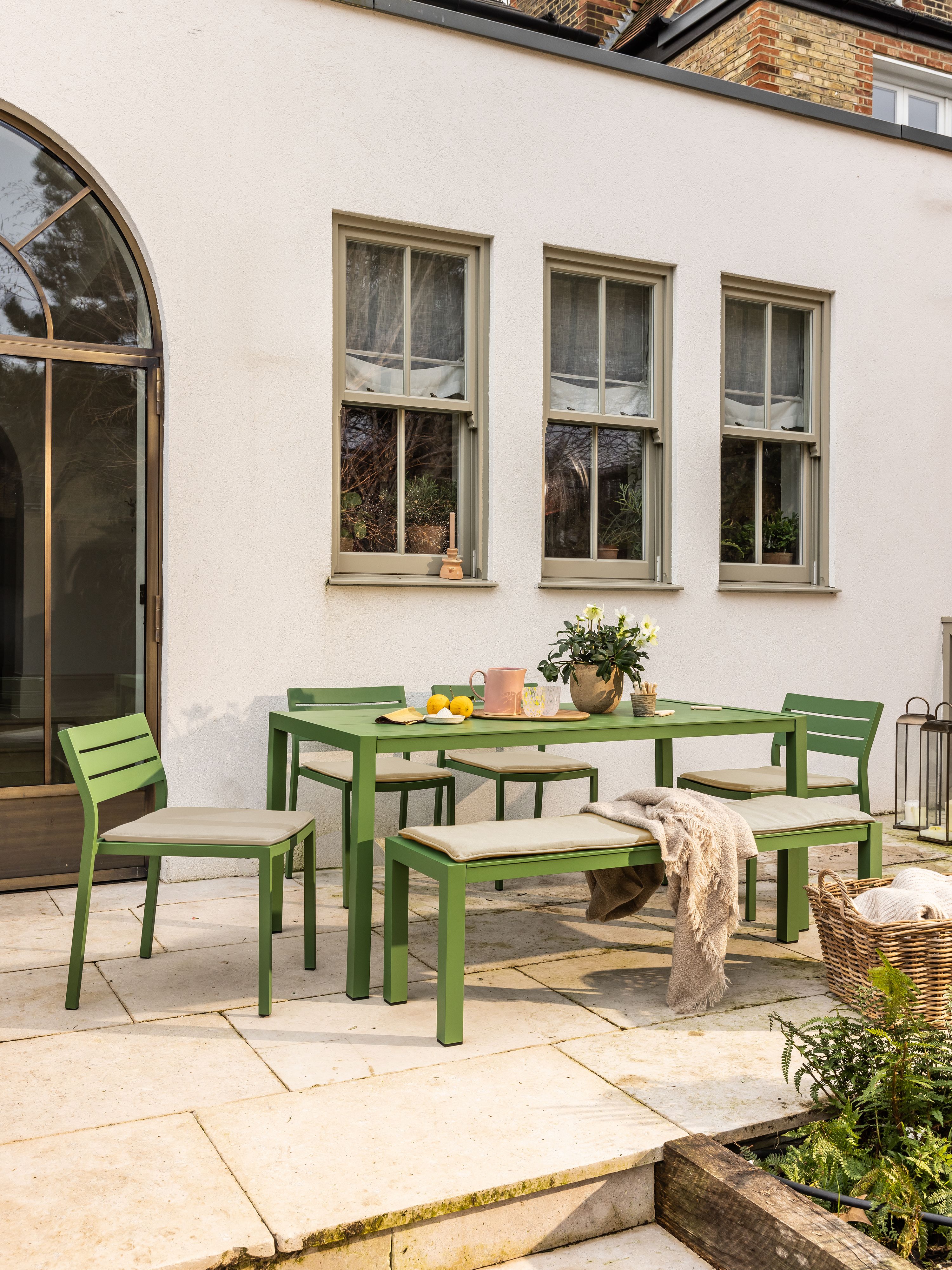 a green outdoor dining table on a patio
