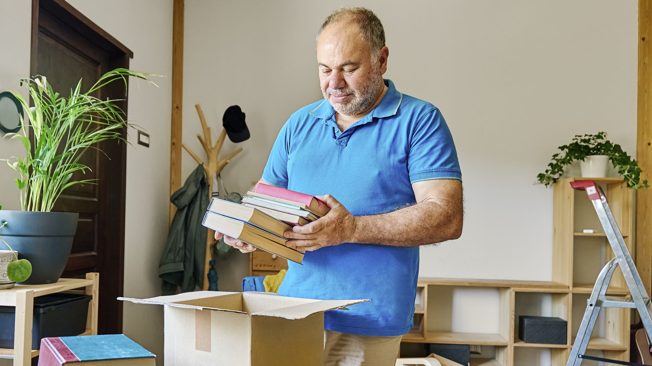 A man putting books into a box to sell