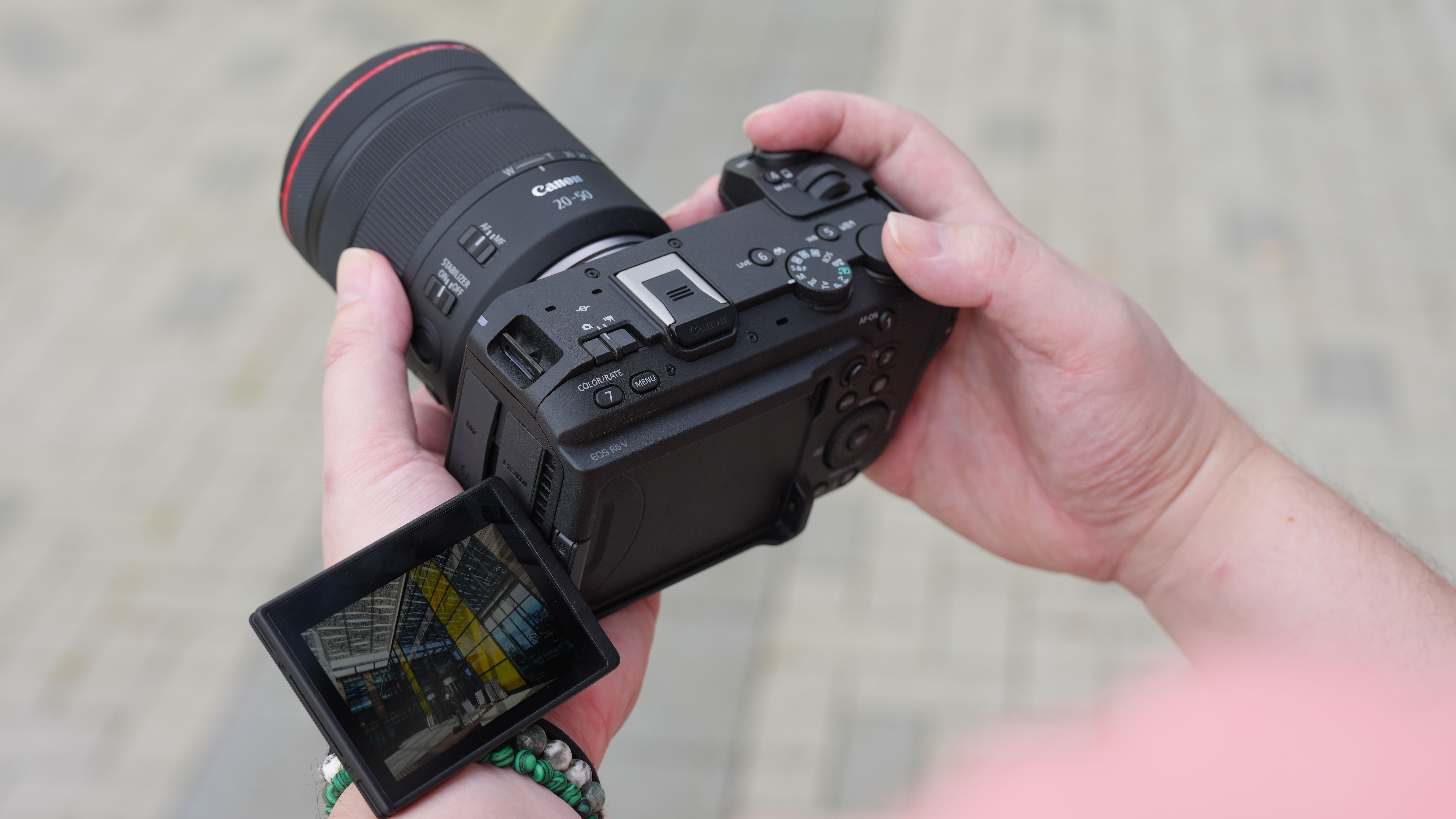 Canon EOS R6 V with the Canon RF 20-50mm f/4L IS USM PZ being held outdoors