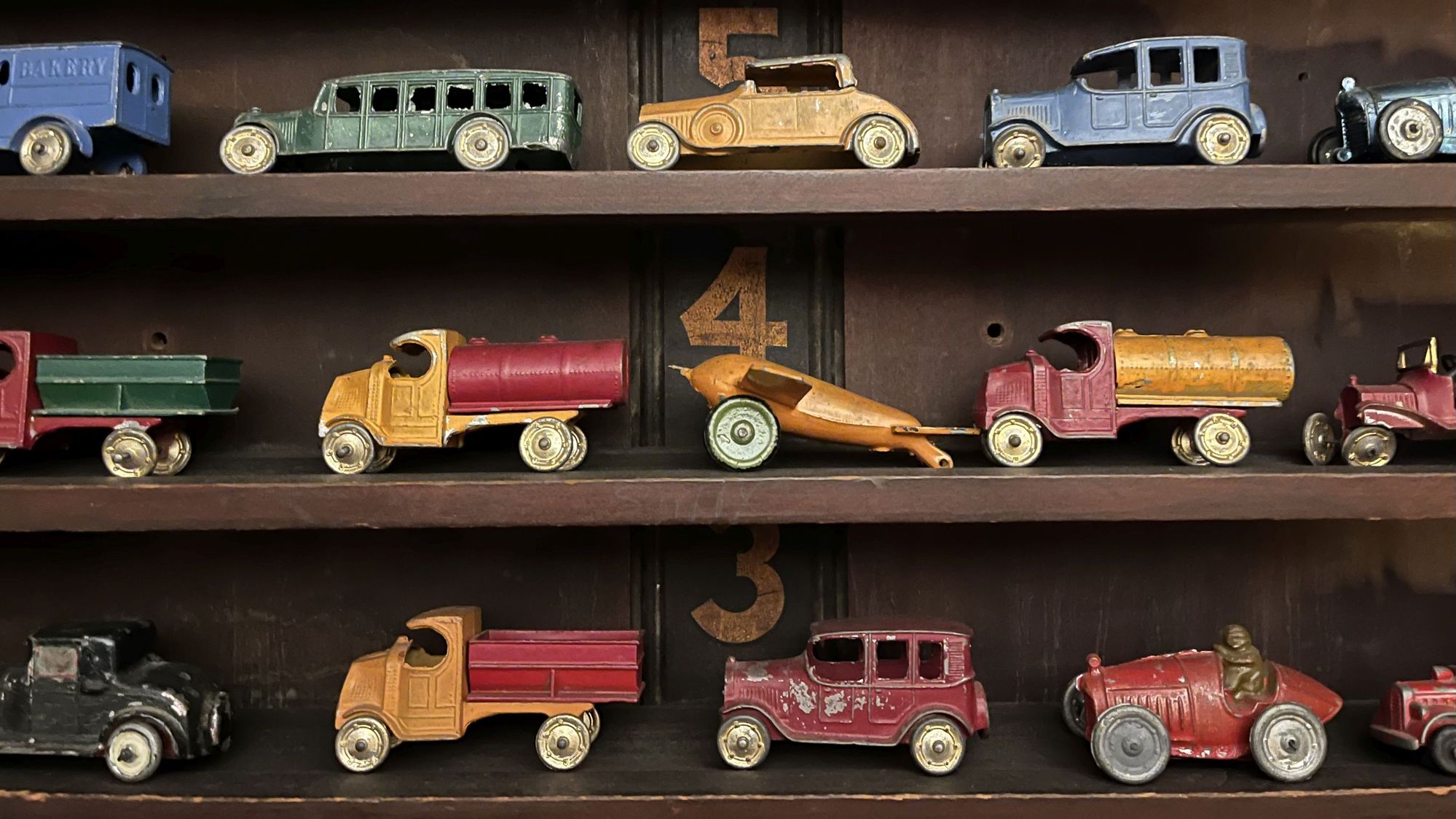 Antique toy cars and trucks. Vintage 1920s toy cars and trucks on shelves.