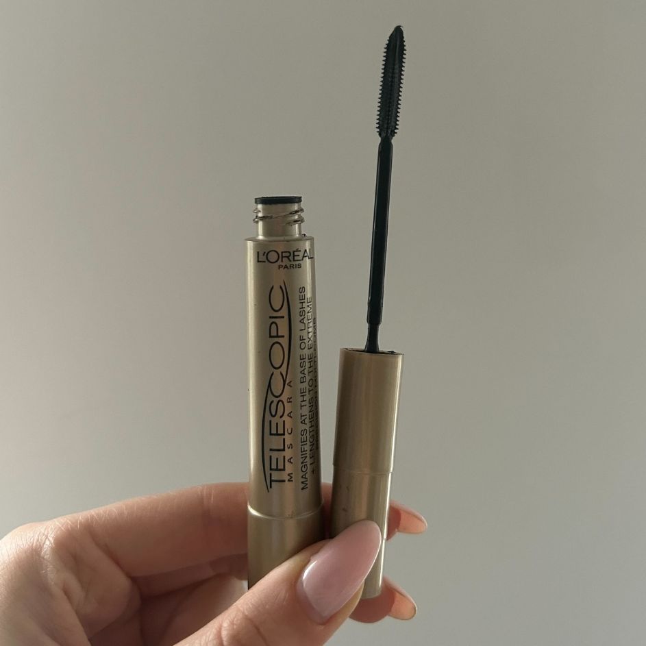 On the left, a close-up of Digital Beauty Writer, Sennen Prickett's hand holding the L'Oreal Telescopic mascara - in front of a white wall - and on the right, a product shot of the same L'Oreal Telescopic mascara, on a white background