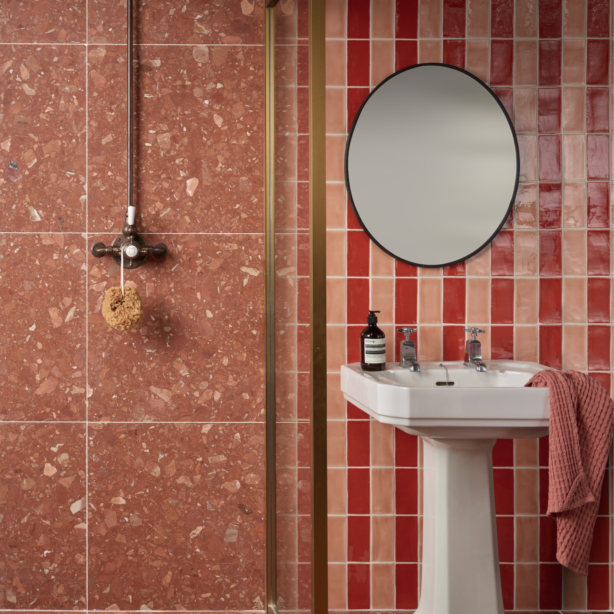 a brown bathroom with brown terazzo tiles and red and pink stripe tiles on the wall