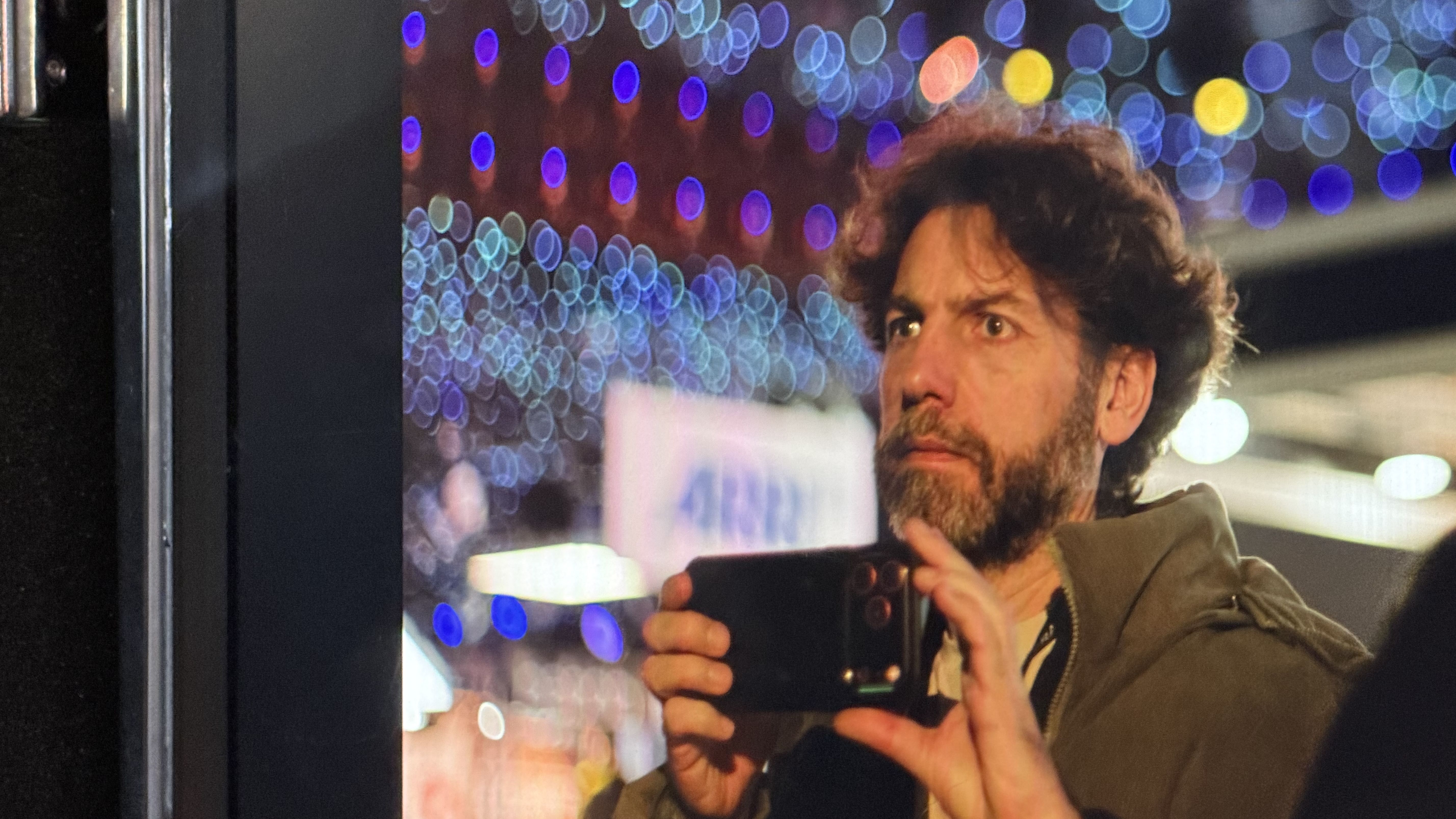 Adam Juniper holding an iPhone with an Arri logo behind him at the BSC show