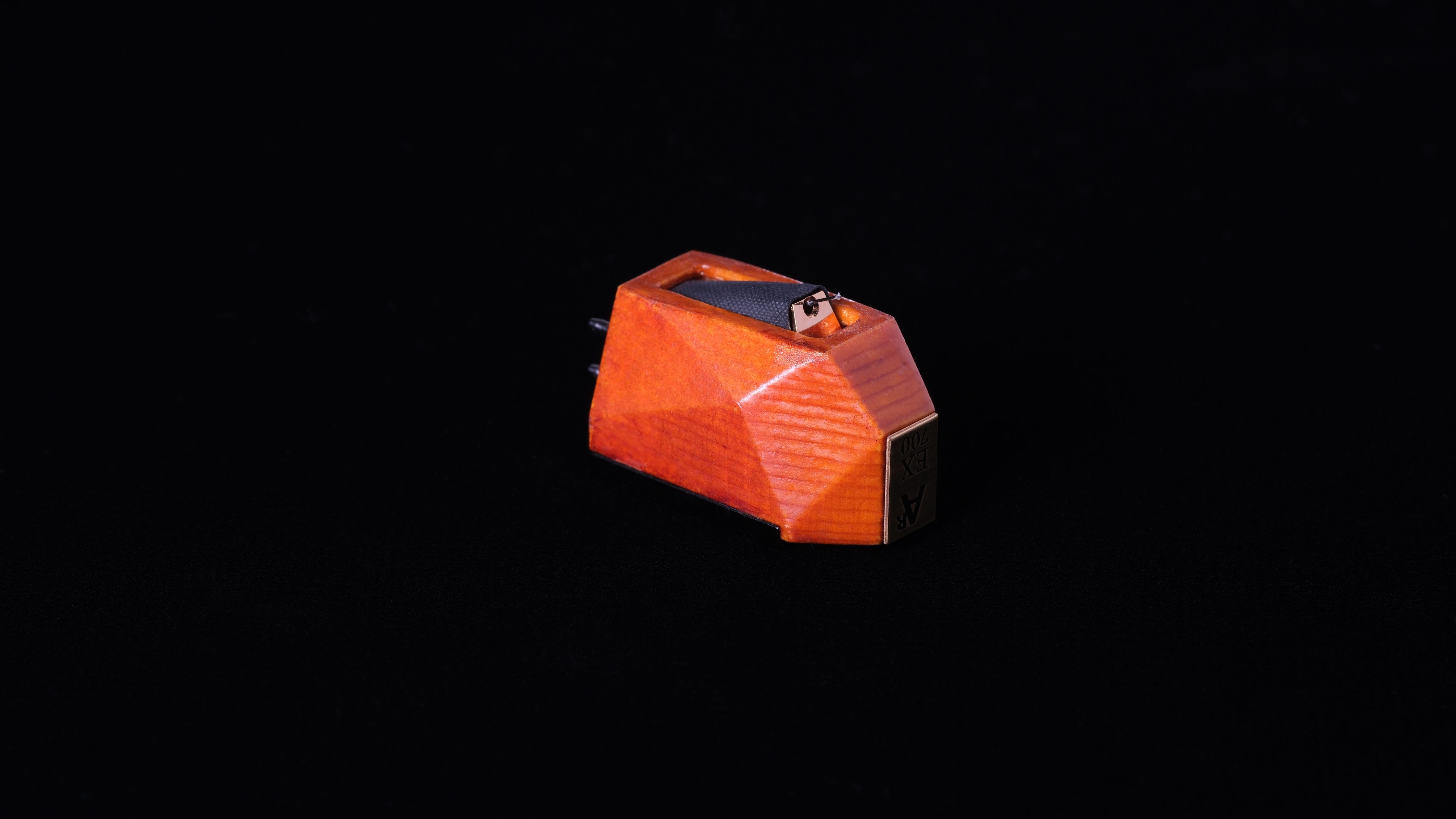 Analog Relax's EX700 cartridge on black background, showing the bodywork in profile, as if elevated from all surfaces