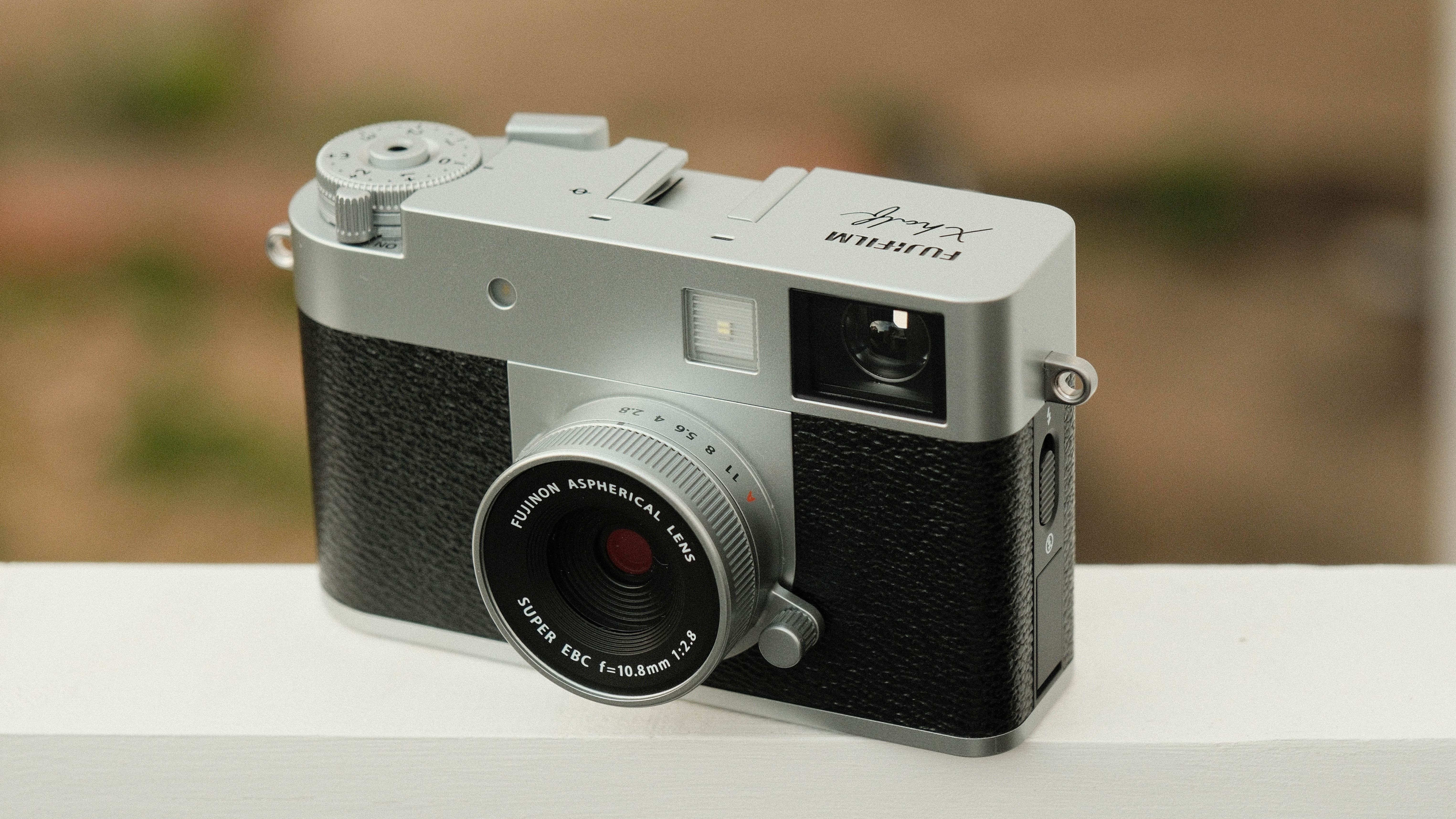 Fujifilm X Half camera balanced on a white bar