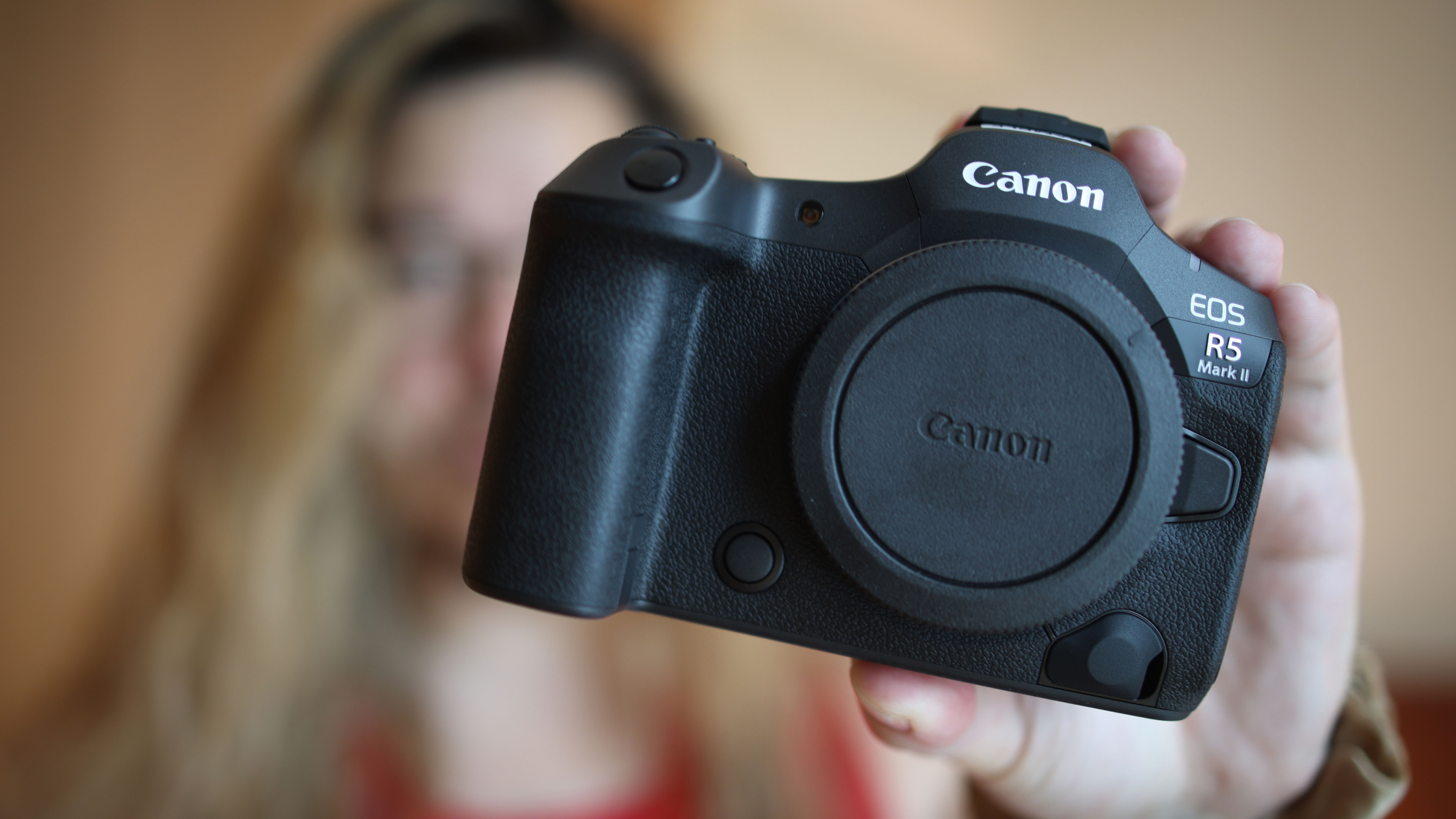 Photographer James Artaius holding up a Canon EOS R5 Mark II