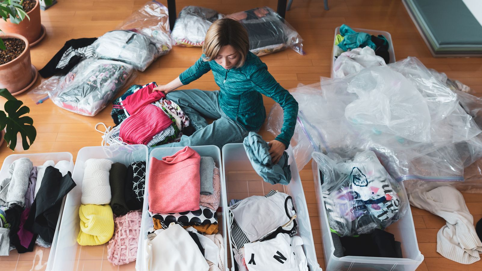 Woman organizes clothes in living room of her home