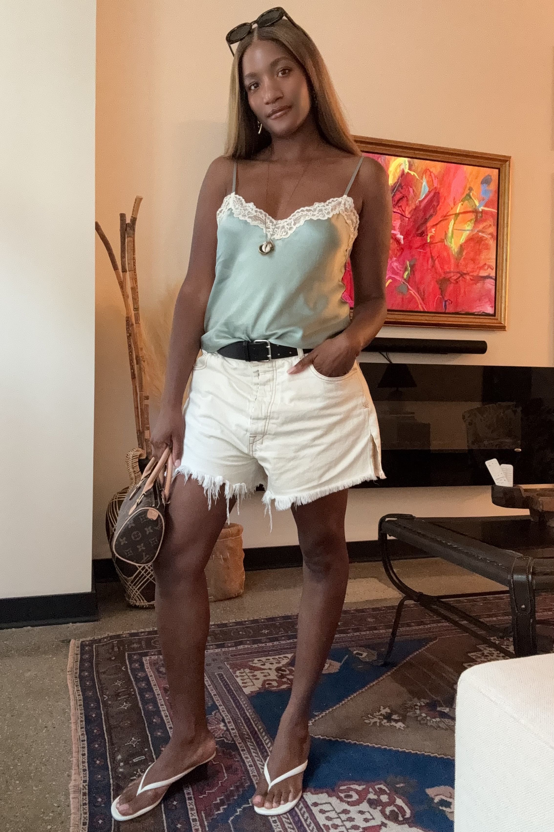 Danielle Prescod styles wedge thongs with white cutoff jeans and a silk top