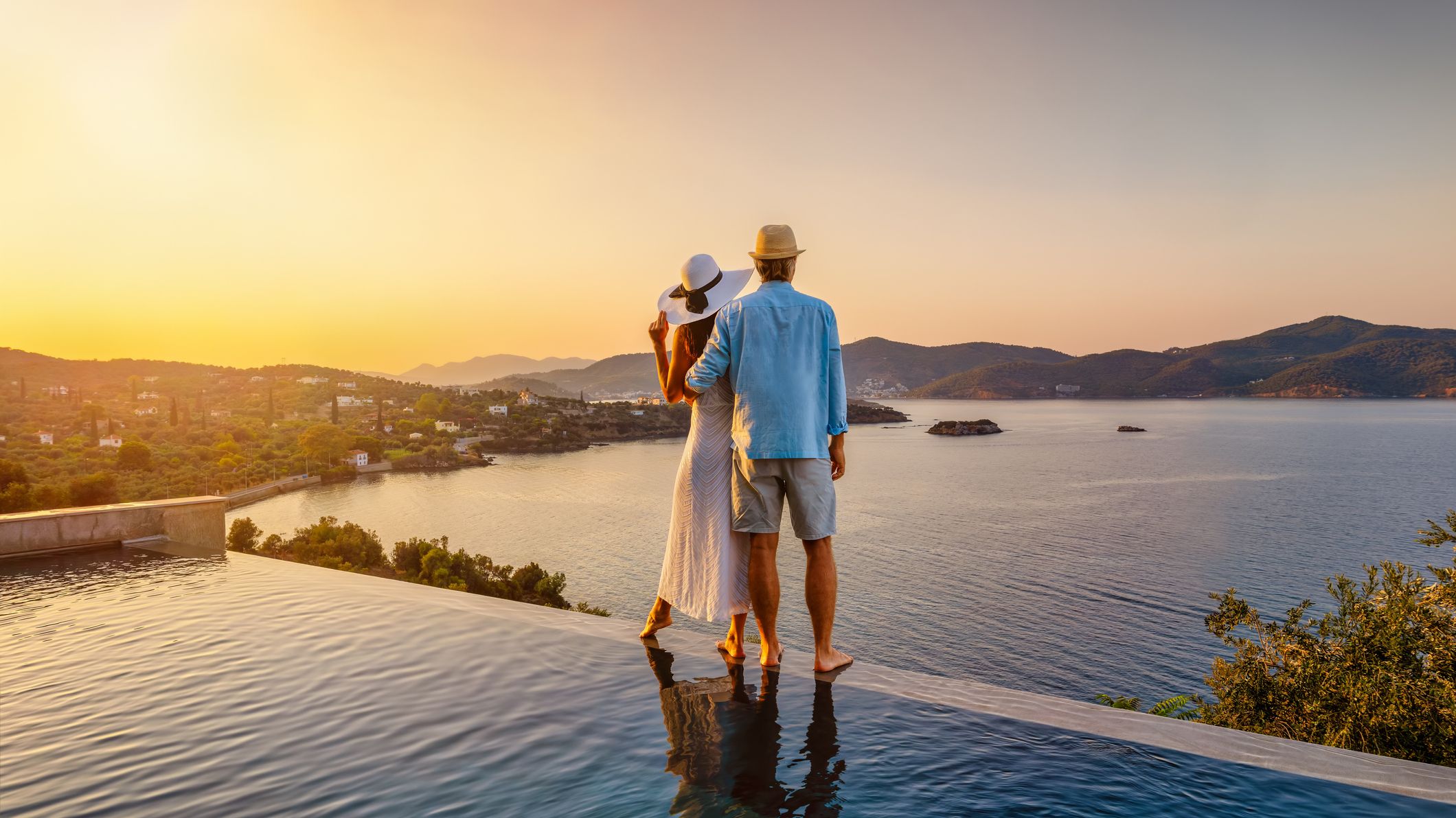 a couple enjoying the sunset in an infinity pool