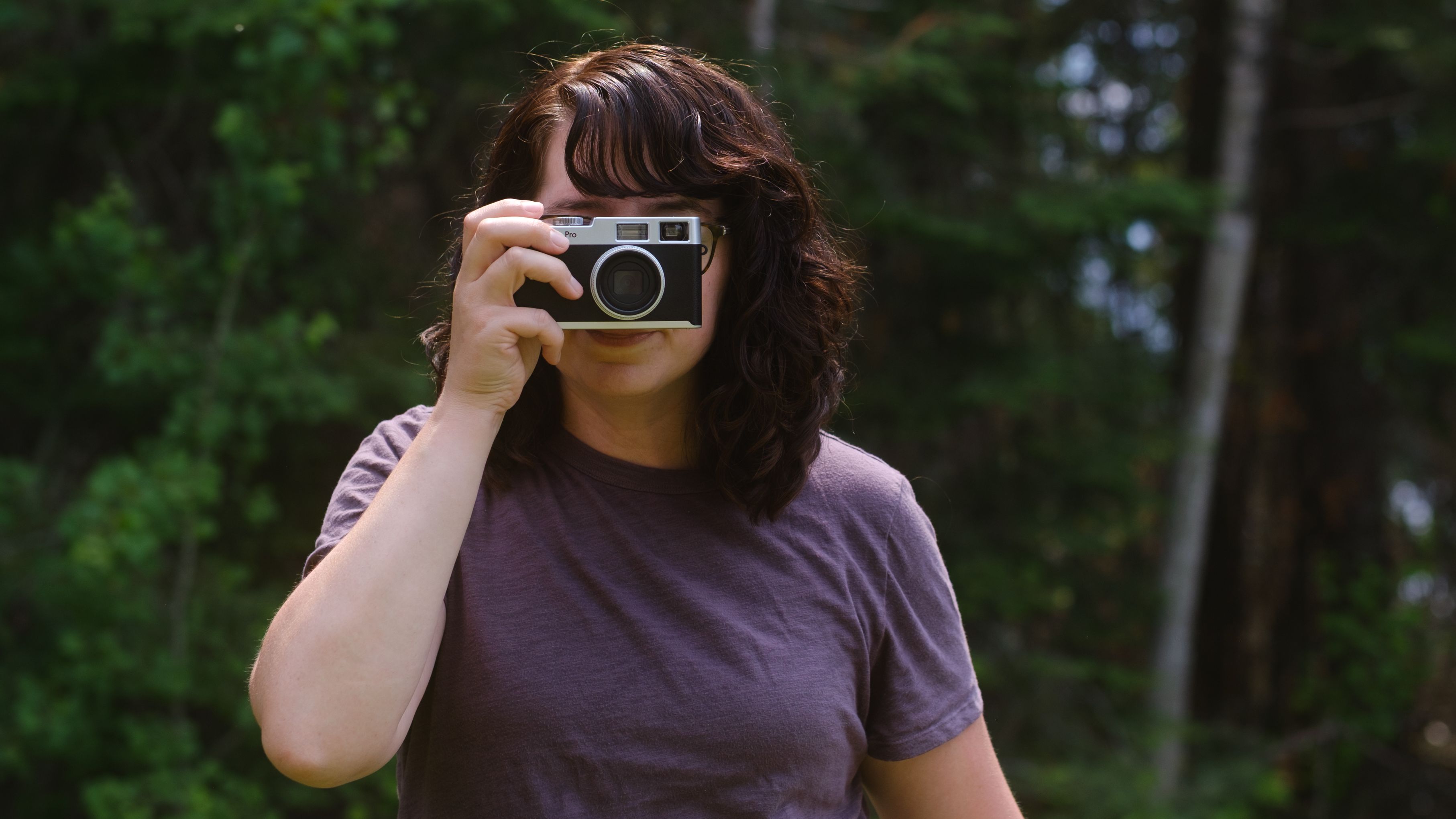 A photographer holds a screen-free digital camera