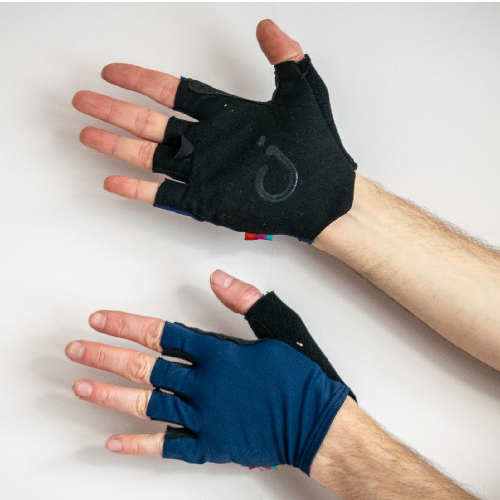 Velocio signature cycling gloves being worn against a white background